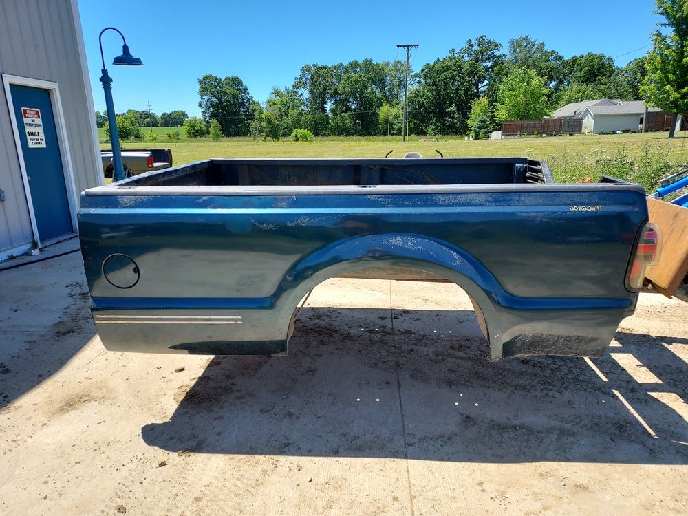 A blue truck bed is sitting in a parking lot