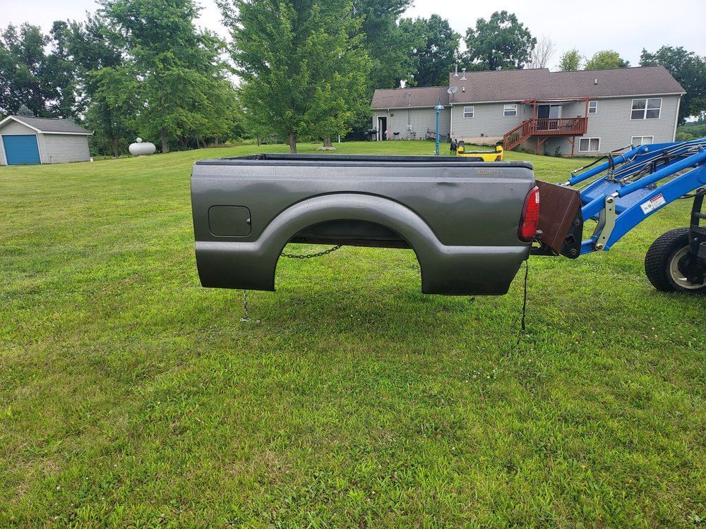 A truck bed is sitting on top of a lush green field.