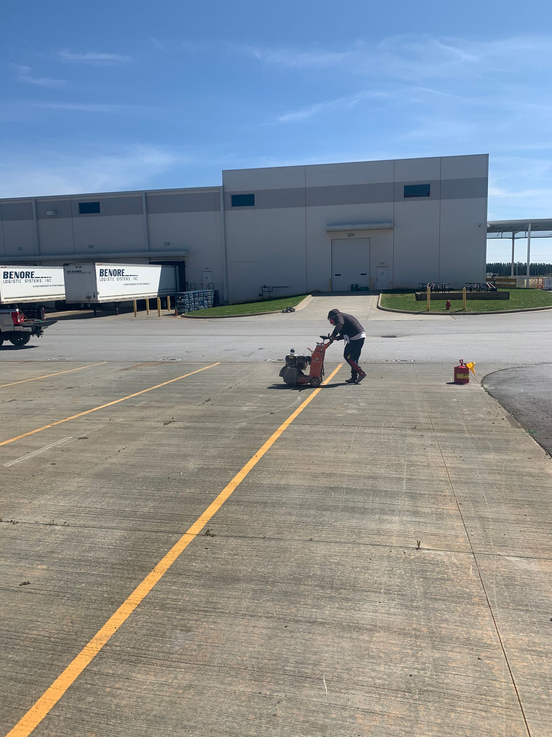 A man is cutting a yellow line in a parking lot
