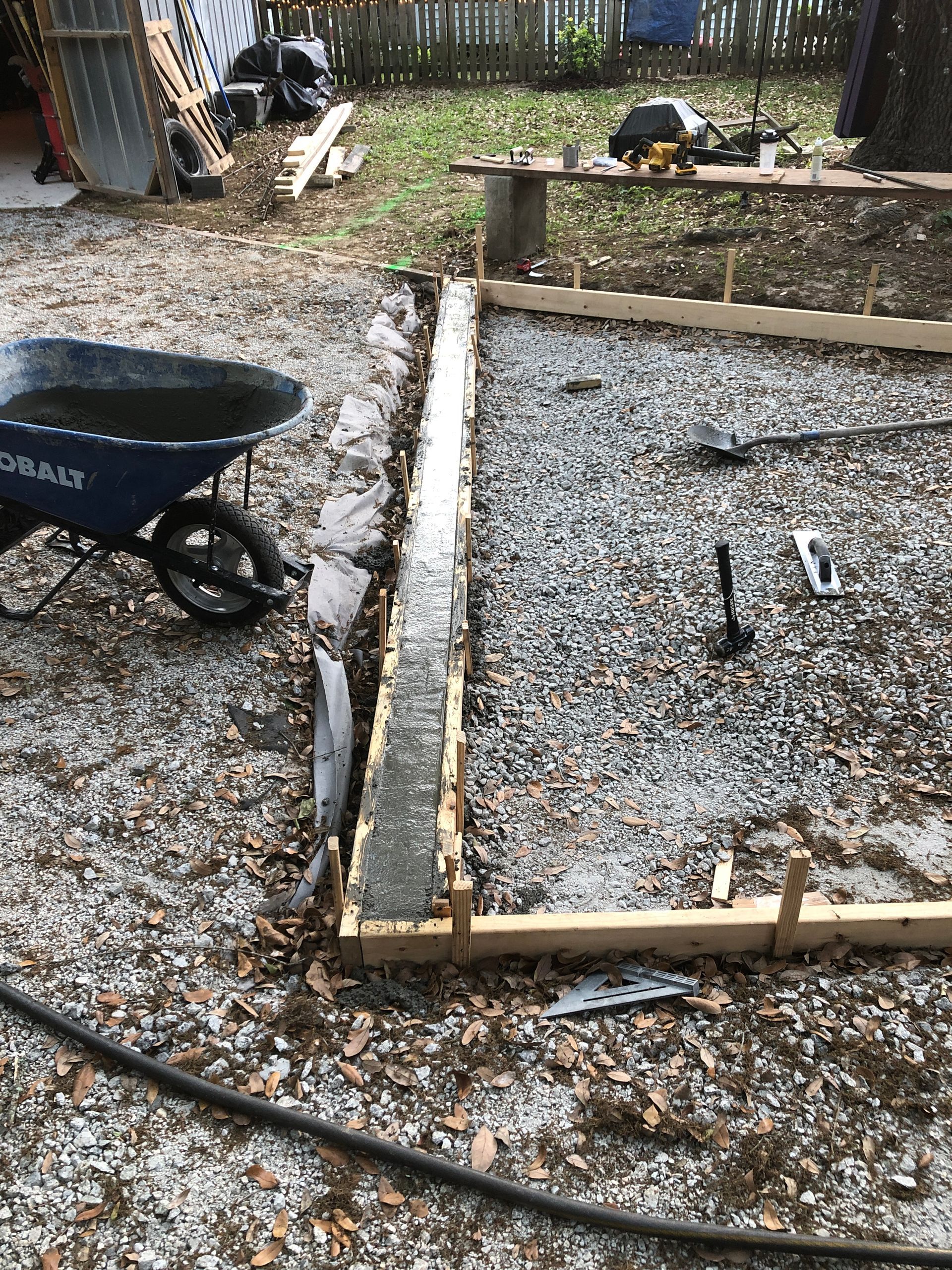 A wheelbarrow is sitting on the ground next to a concrete slab.