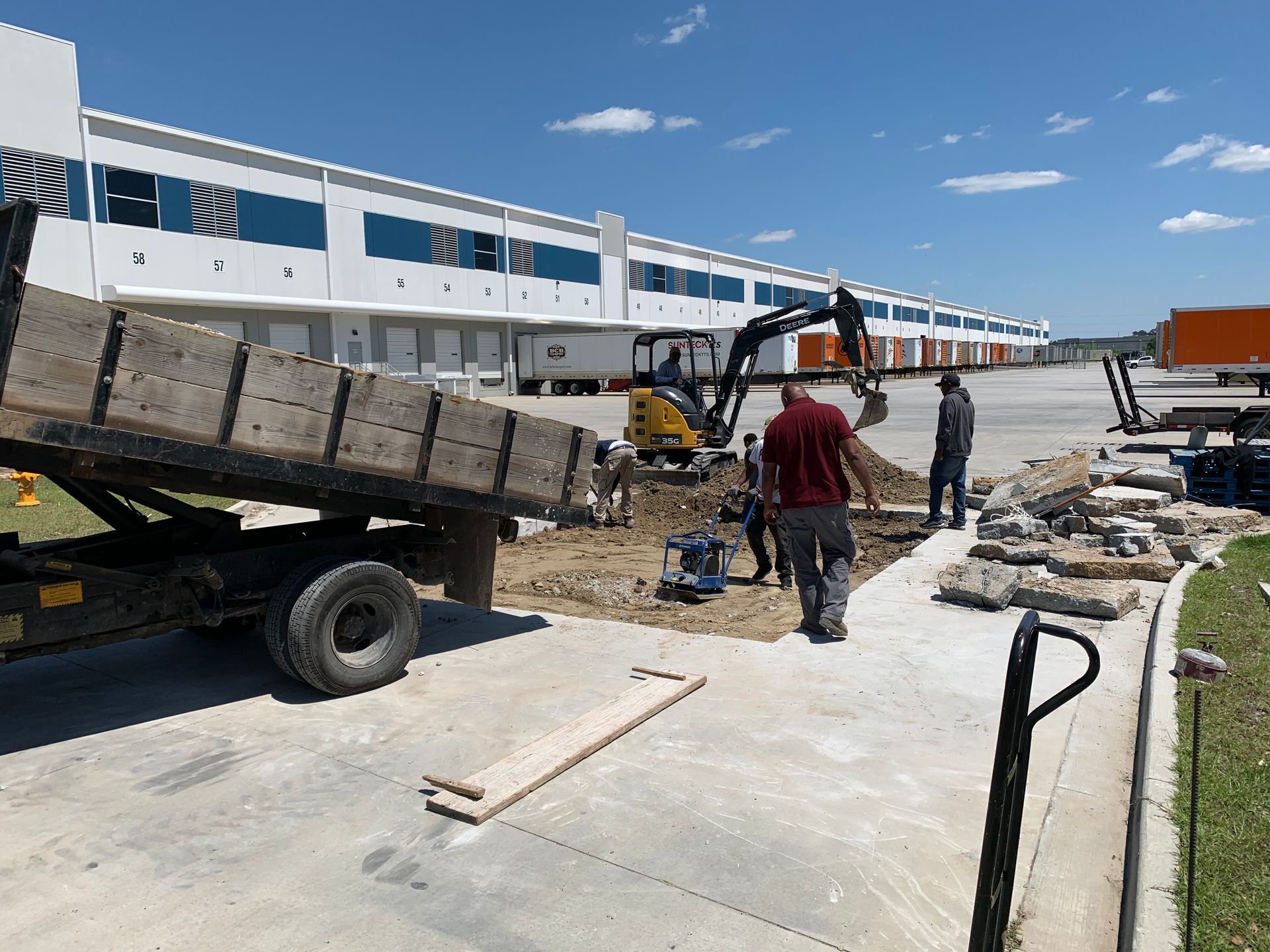 A dump truck is being loaded with concrete in front of a building.