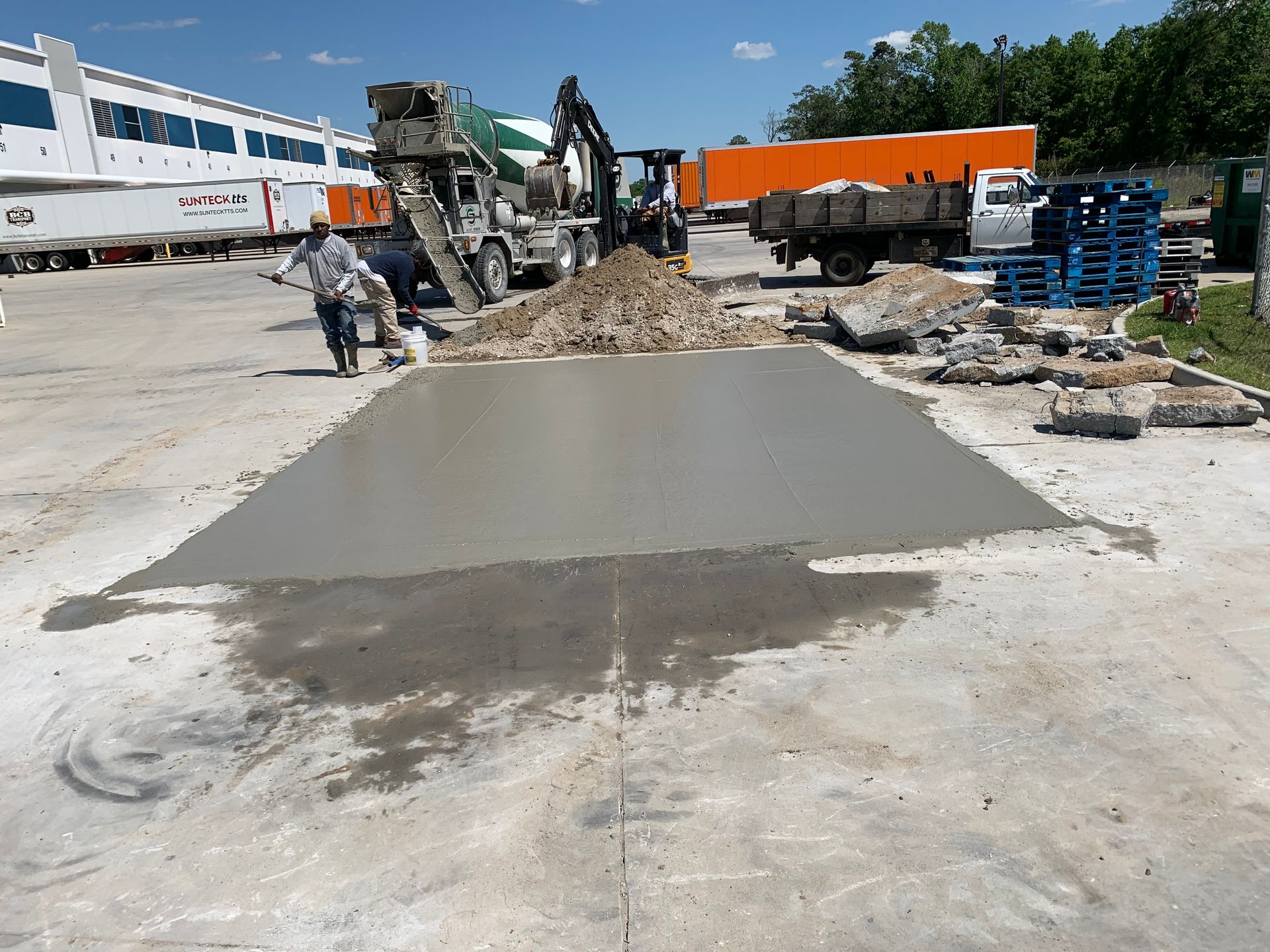 A concrete slab is being poured in a parking lot