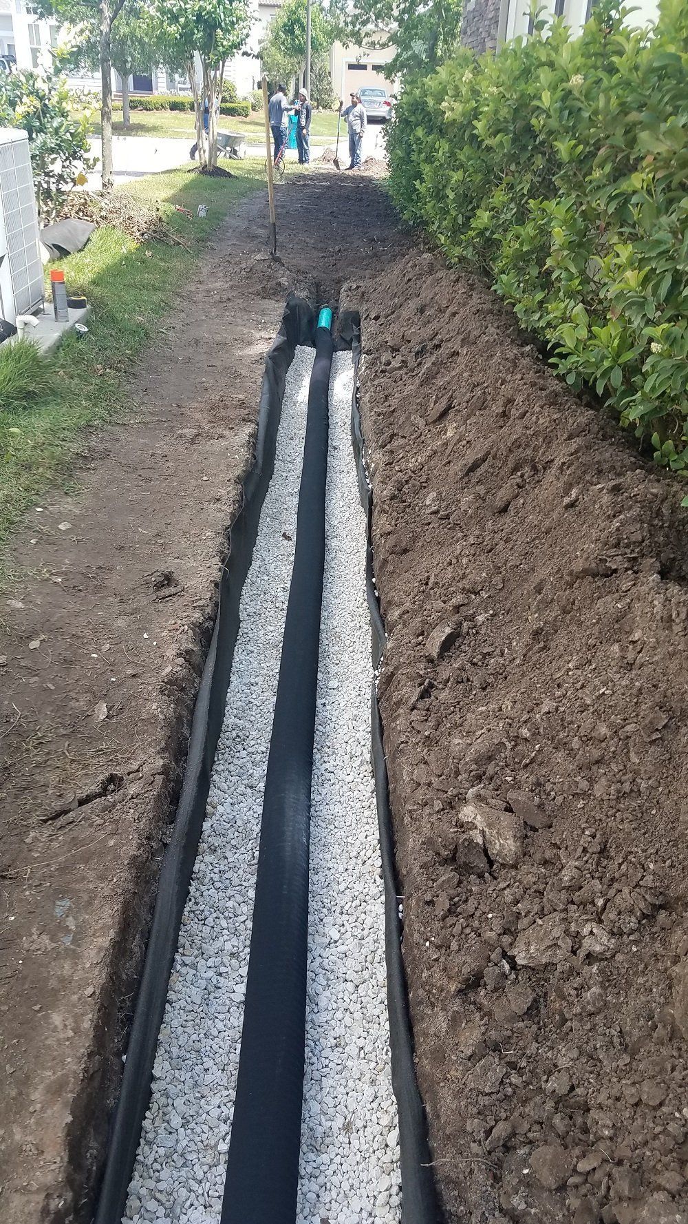 A drainage system is being installed in a yard.