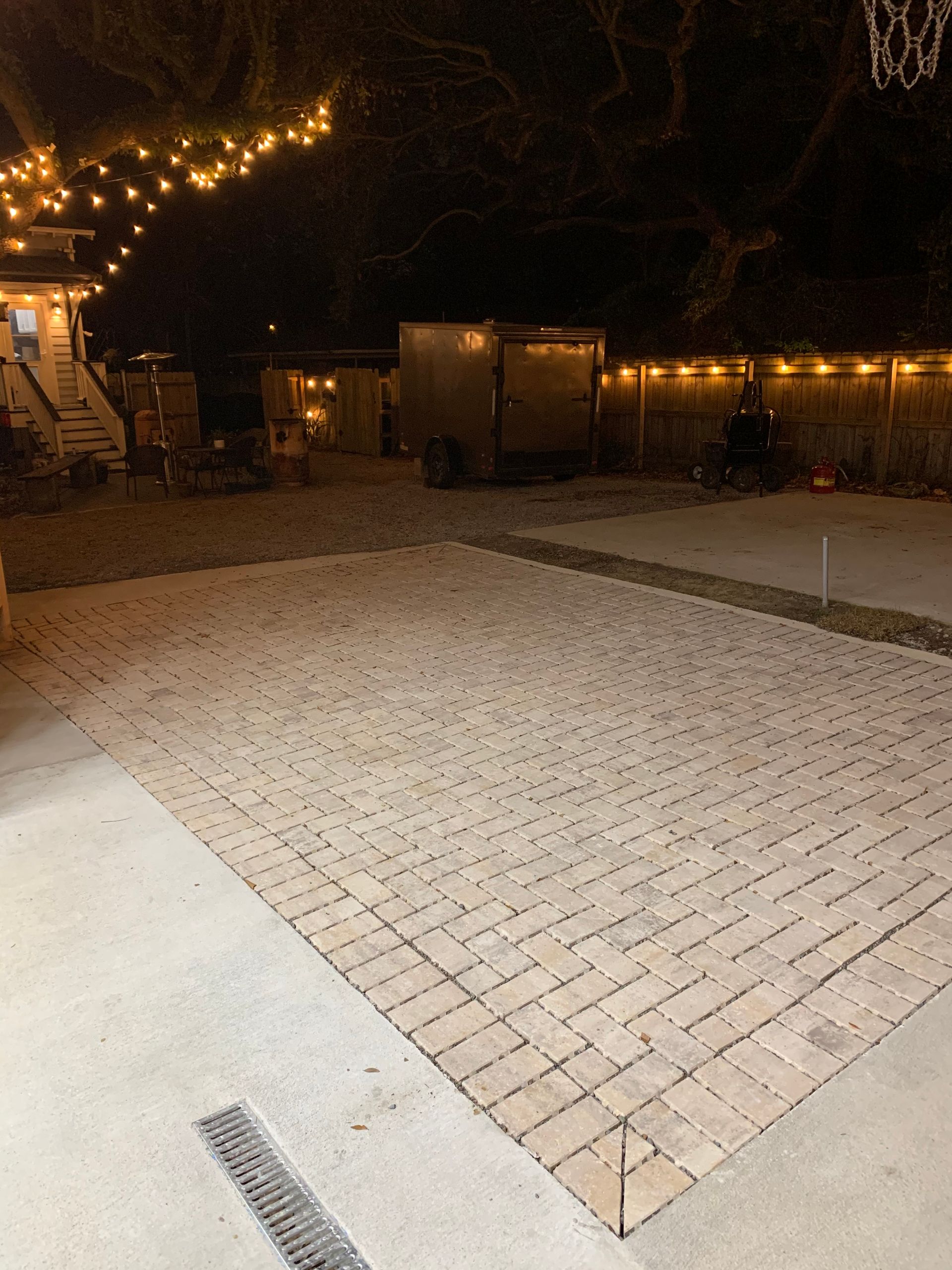 A brick driveway in front of a house at night.