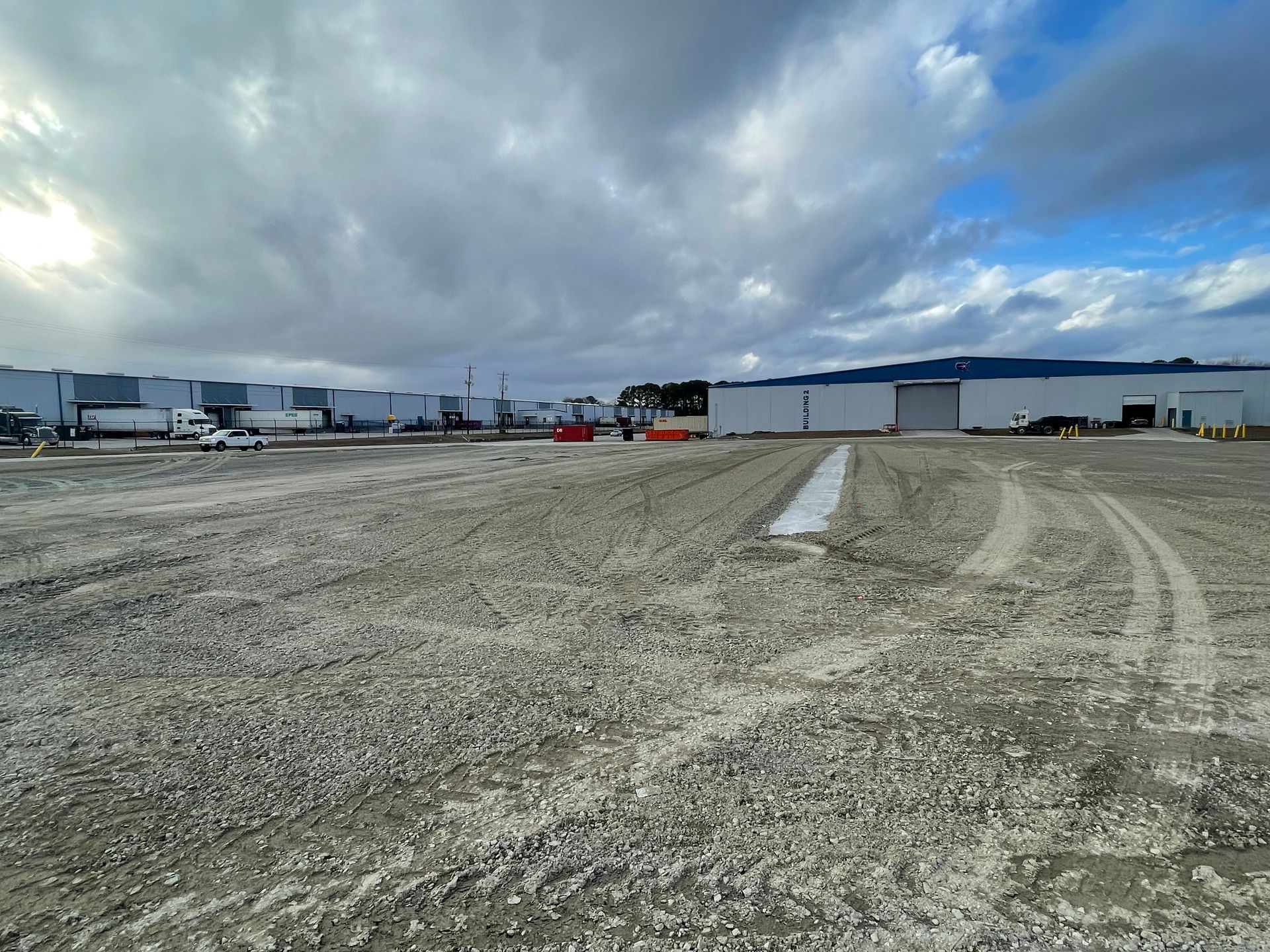 A large dirt field with a building in the background