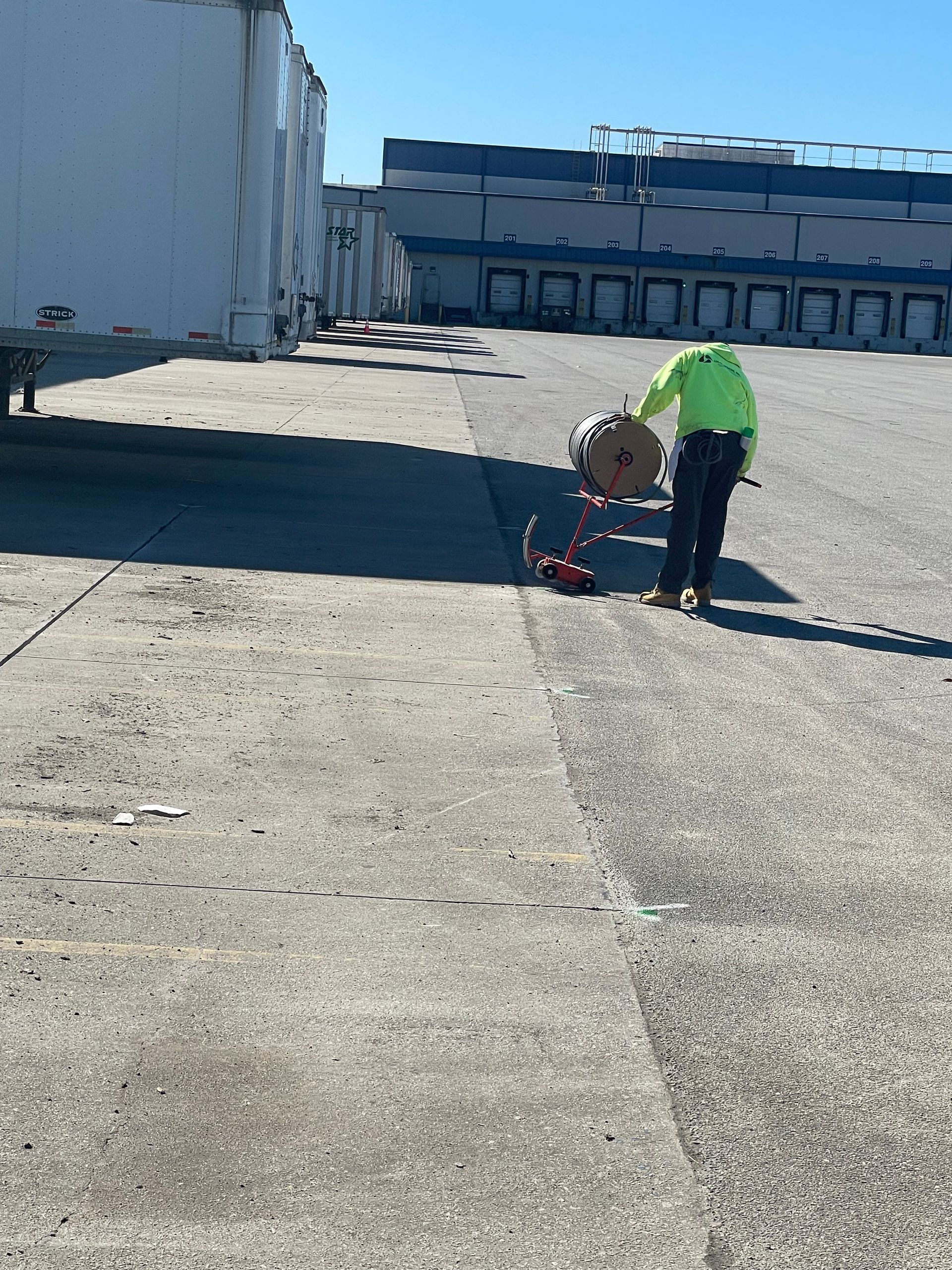 A man pushing a cart with a box on it in a parking lot