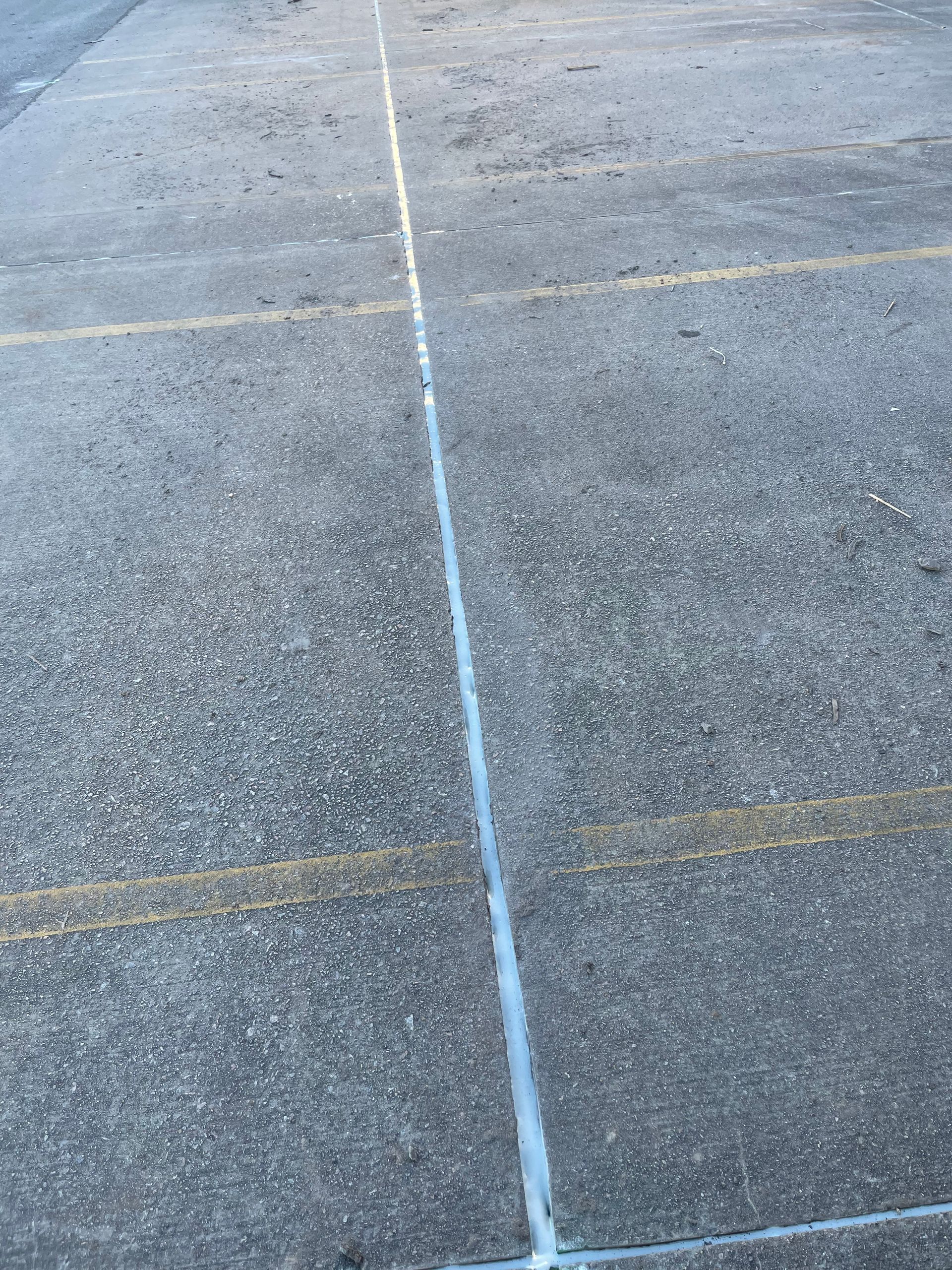 A close up of a parking lot with a white line in the middle.