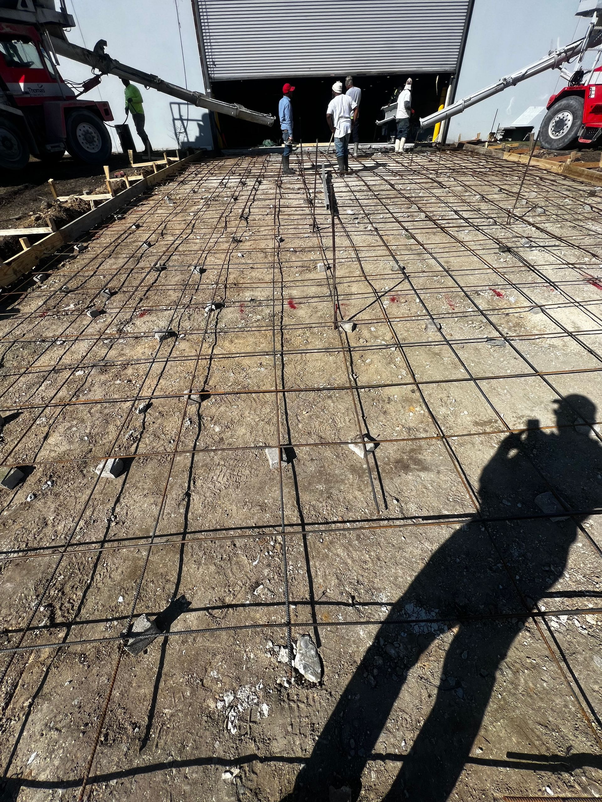 A shadow of a person is cast on a concrete surface.