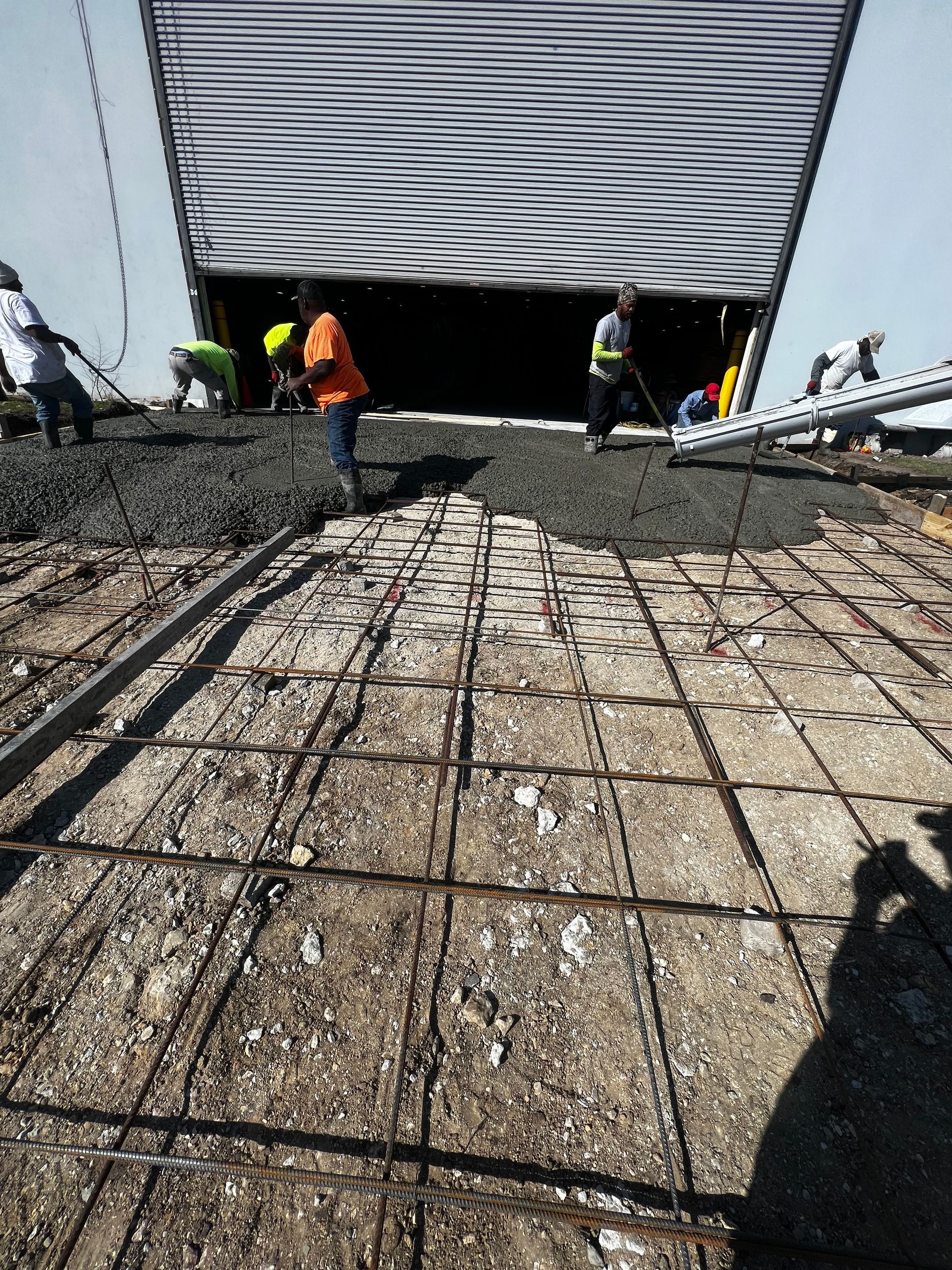 A group of construction workers are working on a concrete floor.