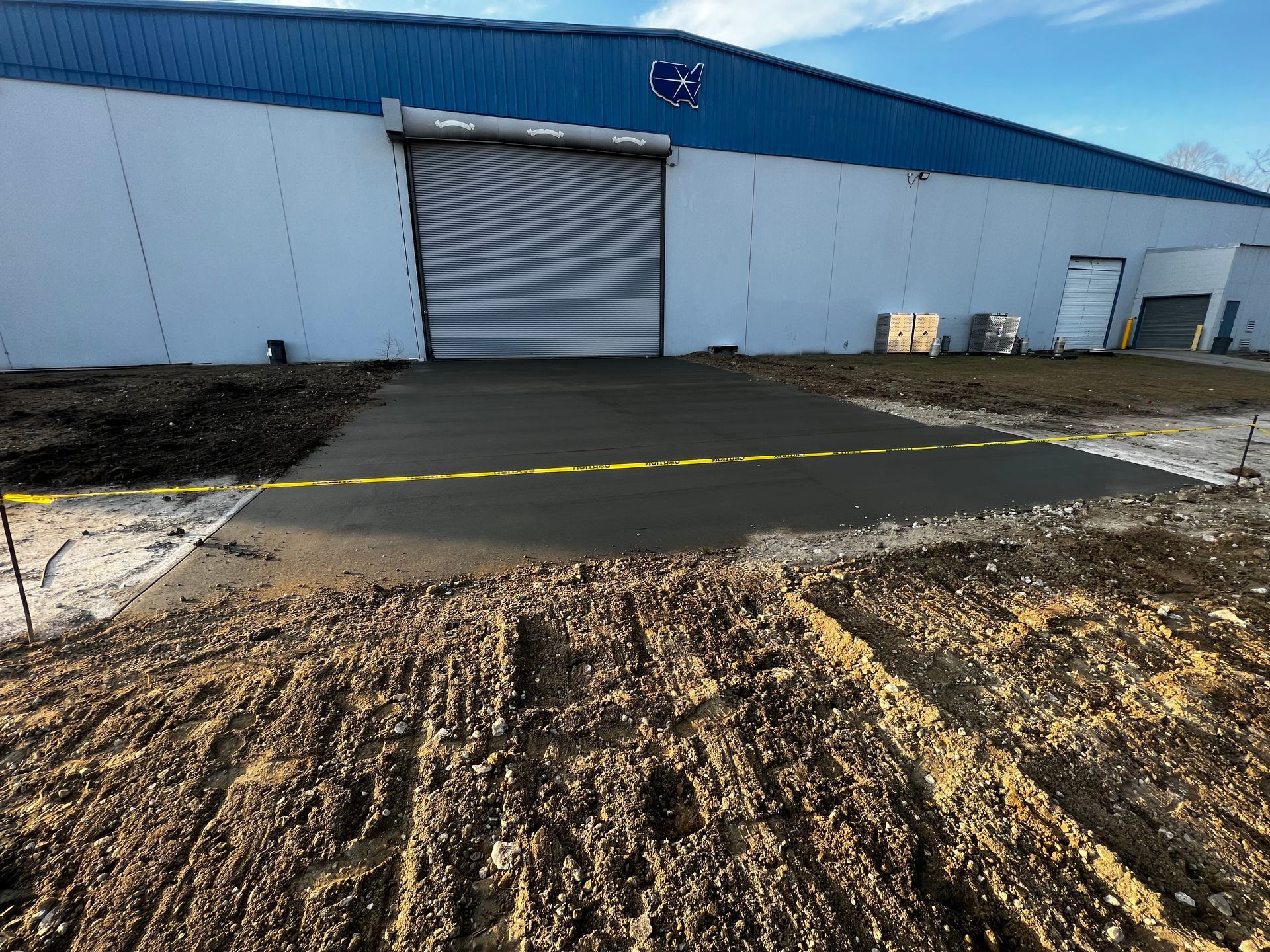 A concrete driveway is being built in front of a large building.