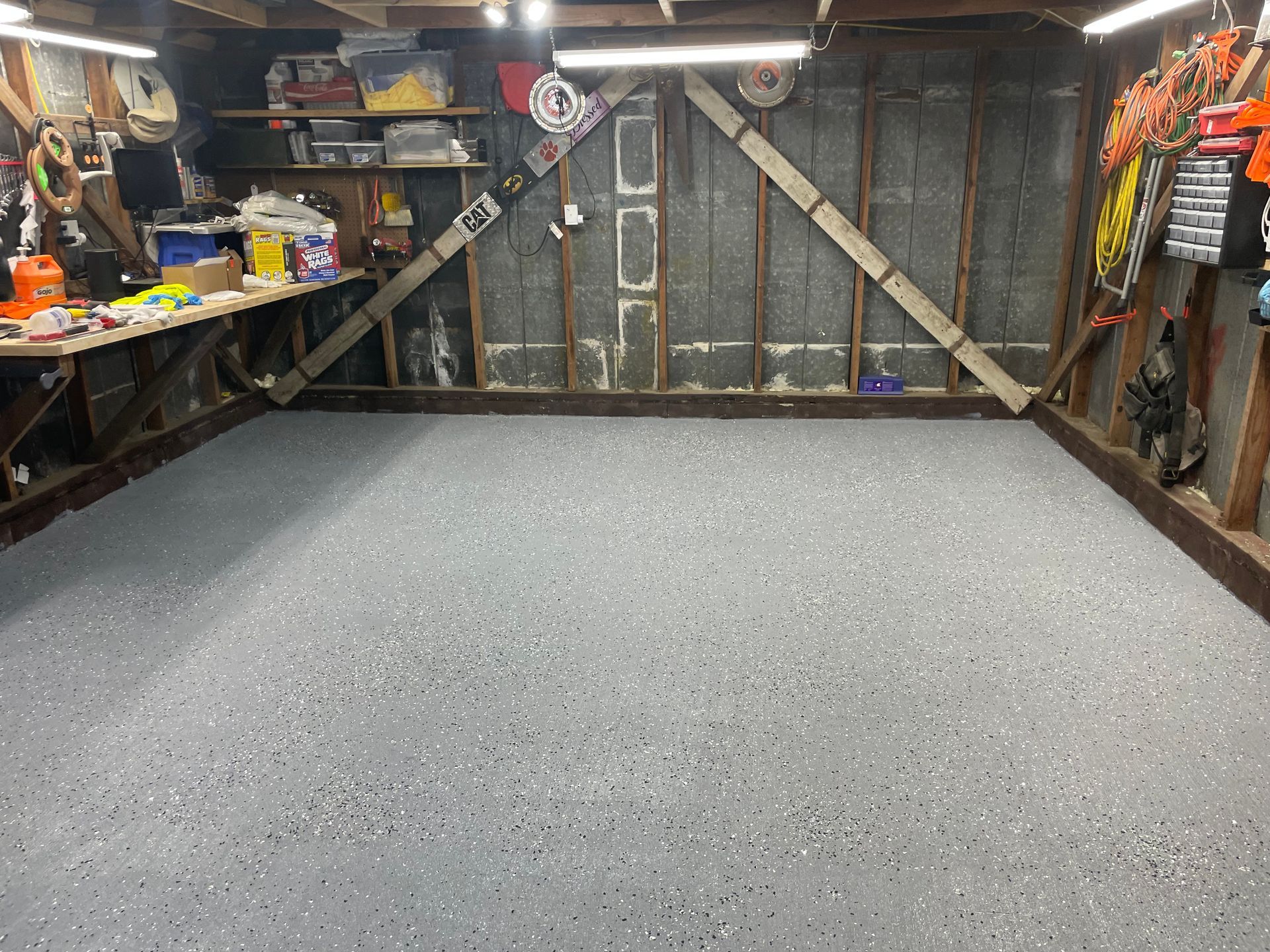 A garage with a concrete floor and a wooden wall.