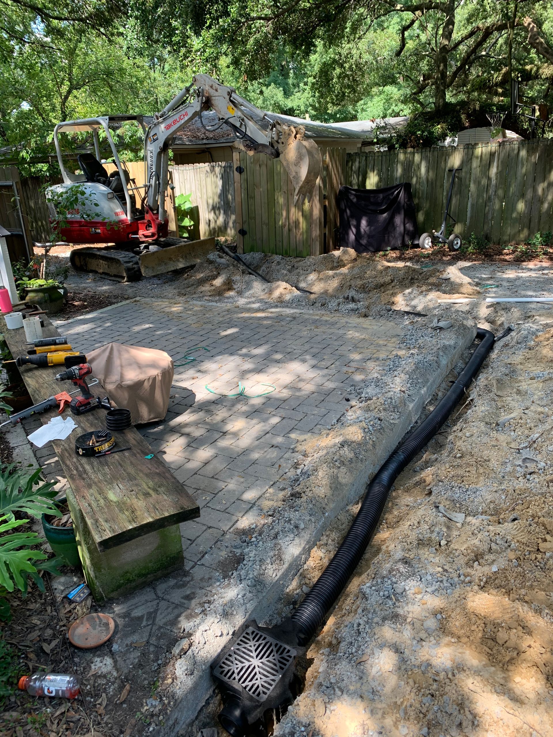 A backyard is being remodeled with a bulldozer.