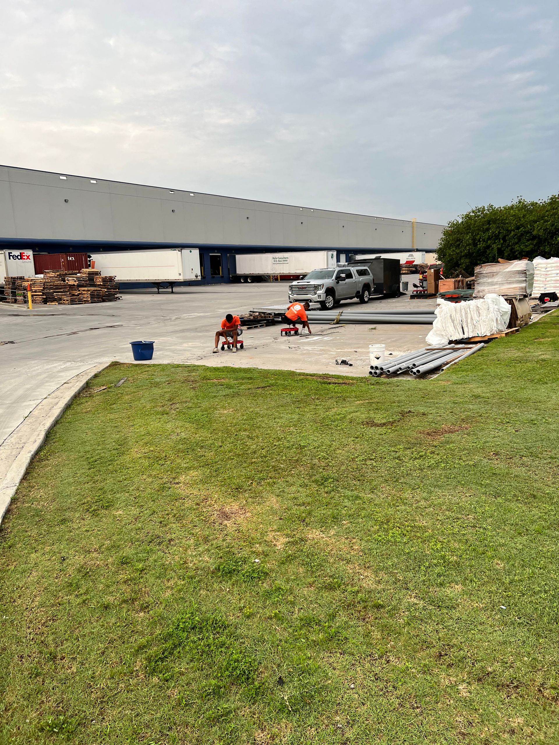 A large warehouse with a lot of trucks parked in front of it.
