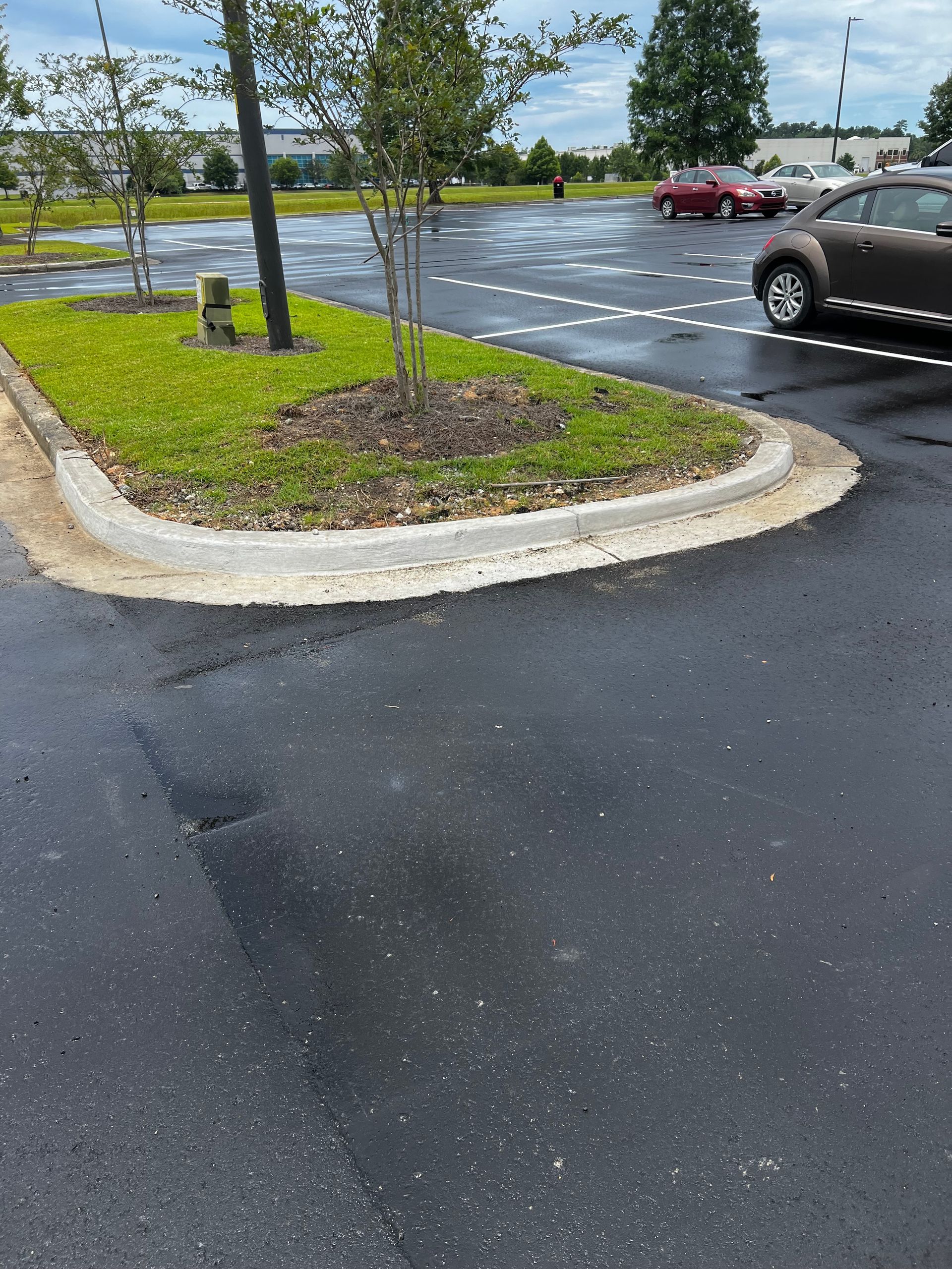 A car is parked on the side of the road in a parking lot