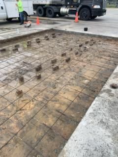 A truck is parked in a parking lot next to a concrete floor.