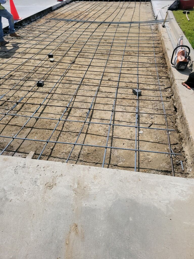 A concrete driveway is being built next to a sidewalk.