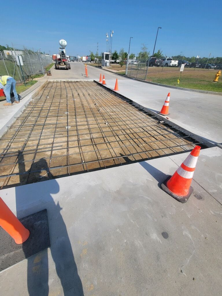 A concrete driveway is being built on a sunny day.