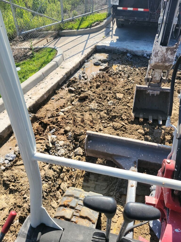A small excavator is digging a hole in the ground.