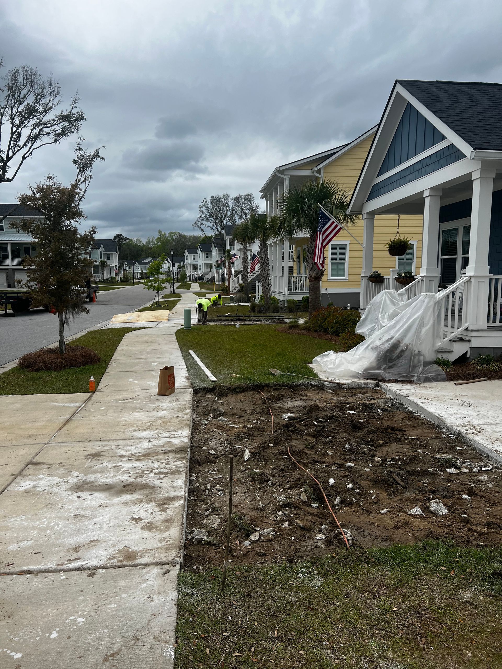 A row of houses in a residential area with a sidewalk in front of them.