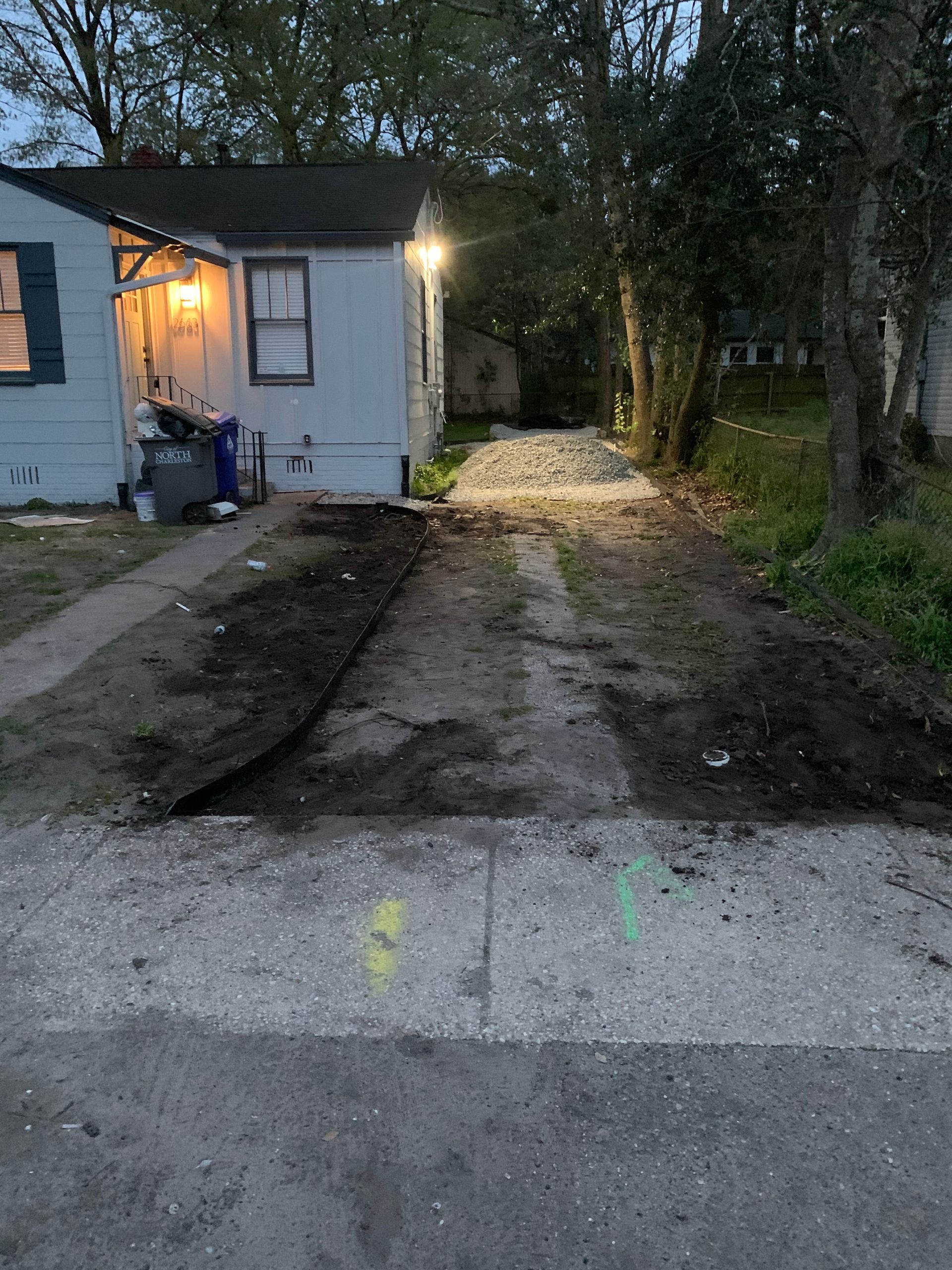 A house with a dirt driveway leading to it.