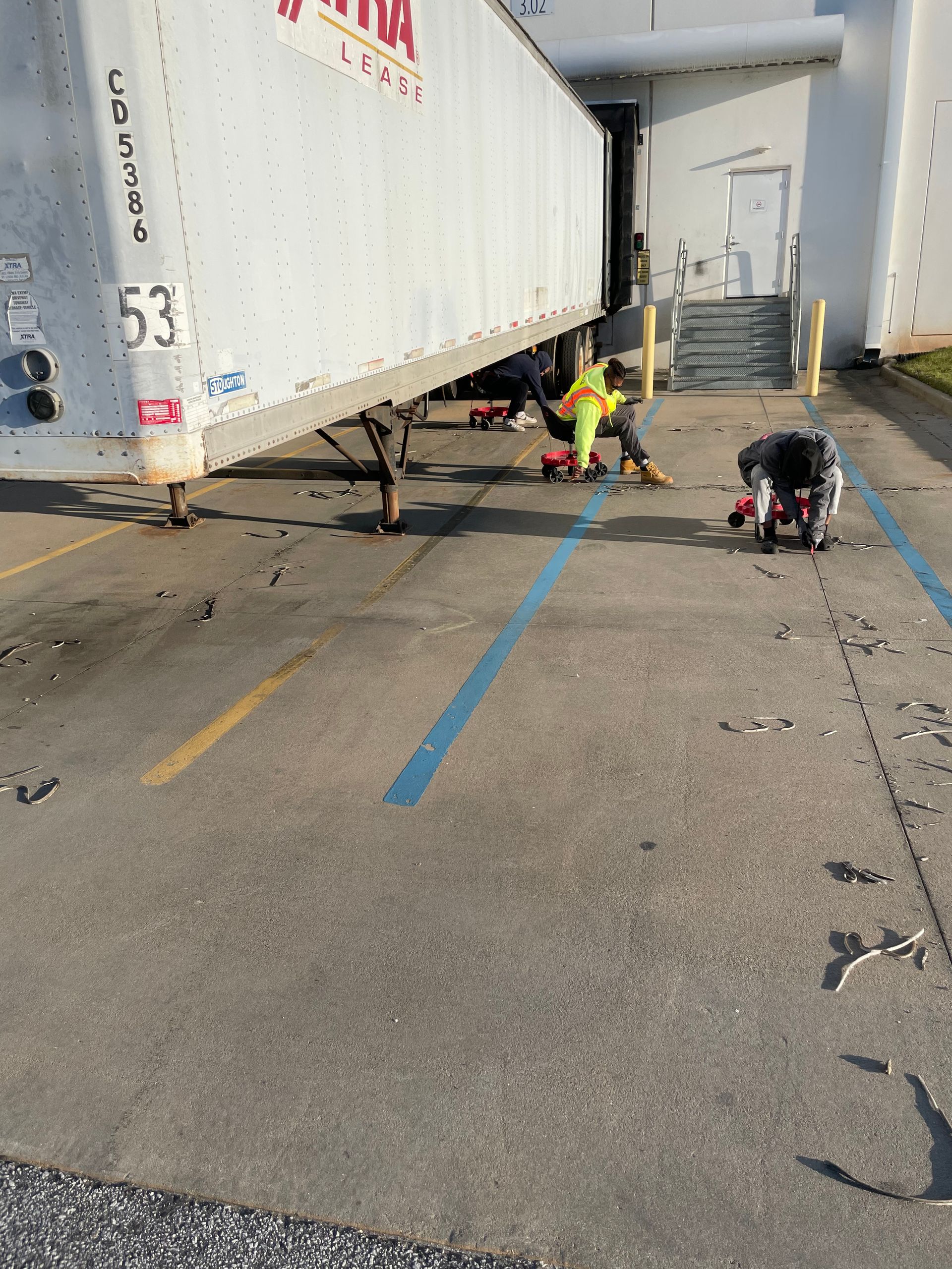 A white trailer with the number 53 on it is parked in a parking lot.