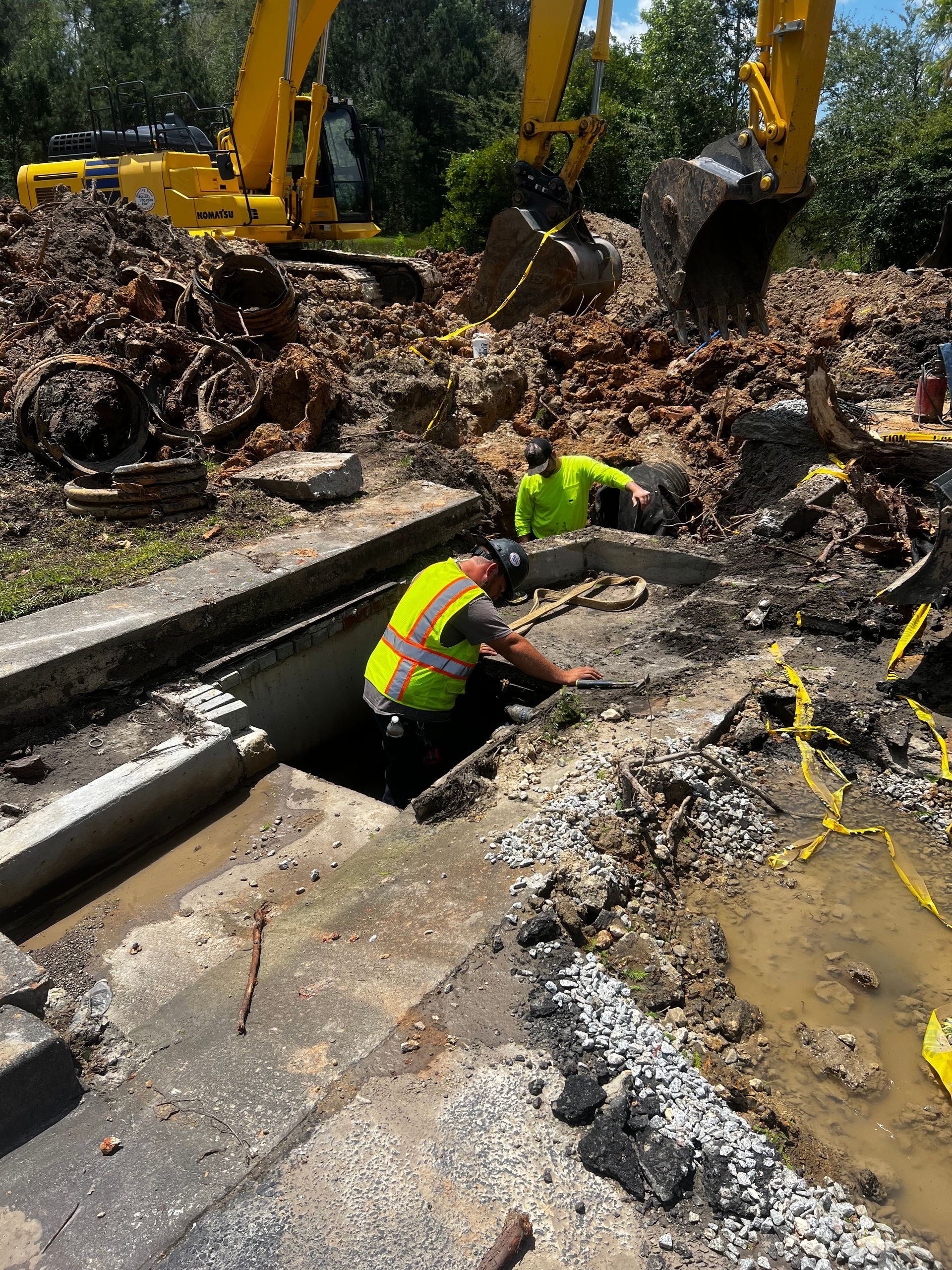 A man is crawling out of a hole in the ground.