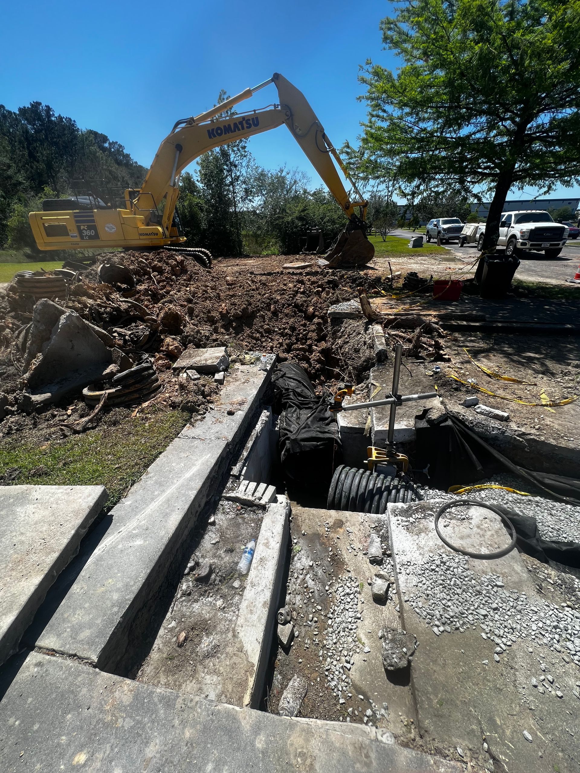 A yellow excavator is digging a hole in the ground