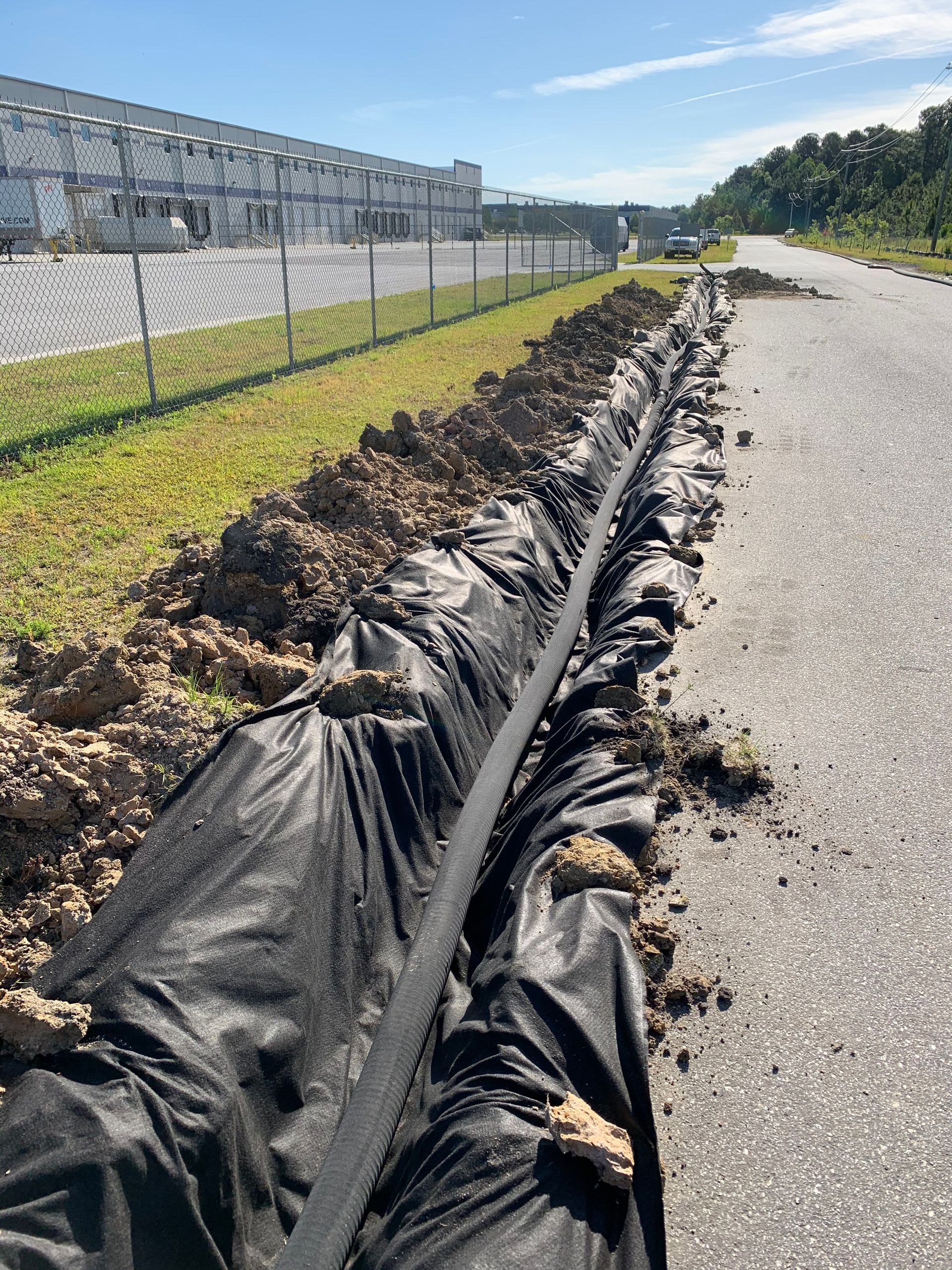 A drainage pipe is being installed on the side of a road.