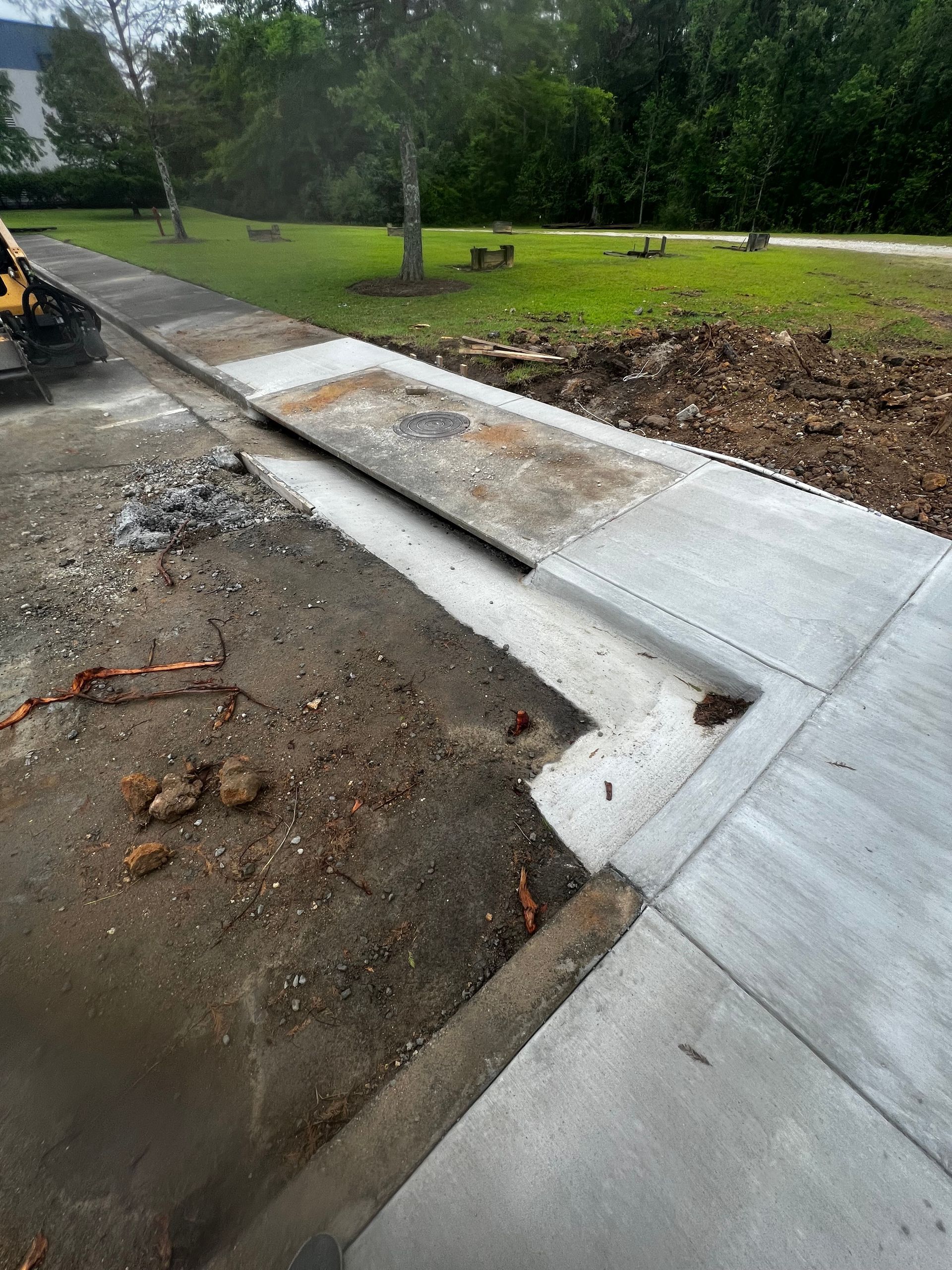 A concrete sidewalk is being built on the side of a road.