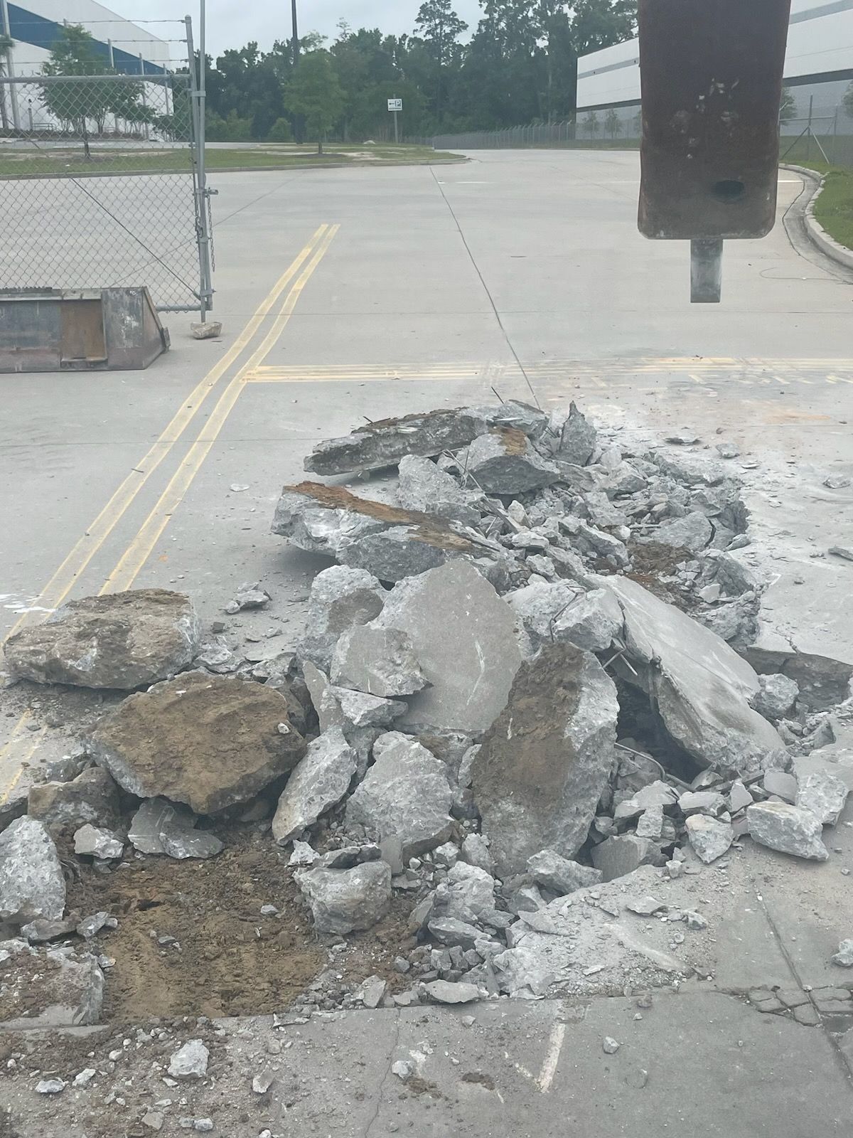 A pile of rocks is laying on the ground in a parking lot.
