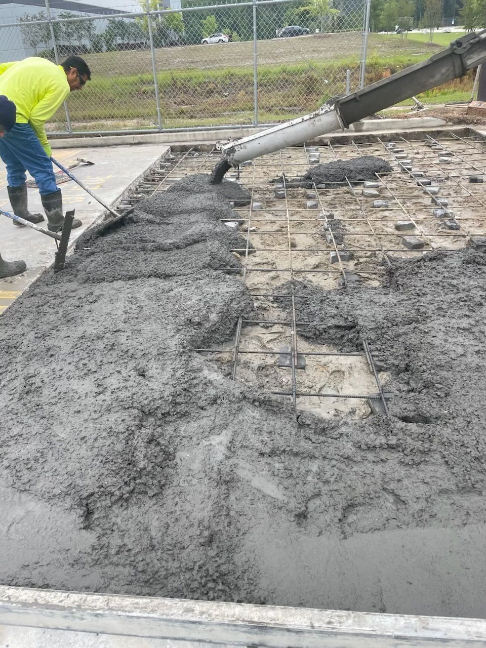 A man is pouring concrete into a concrete slab