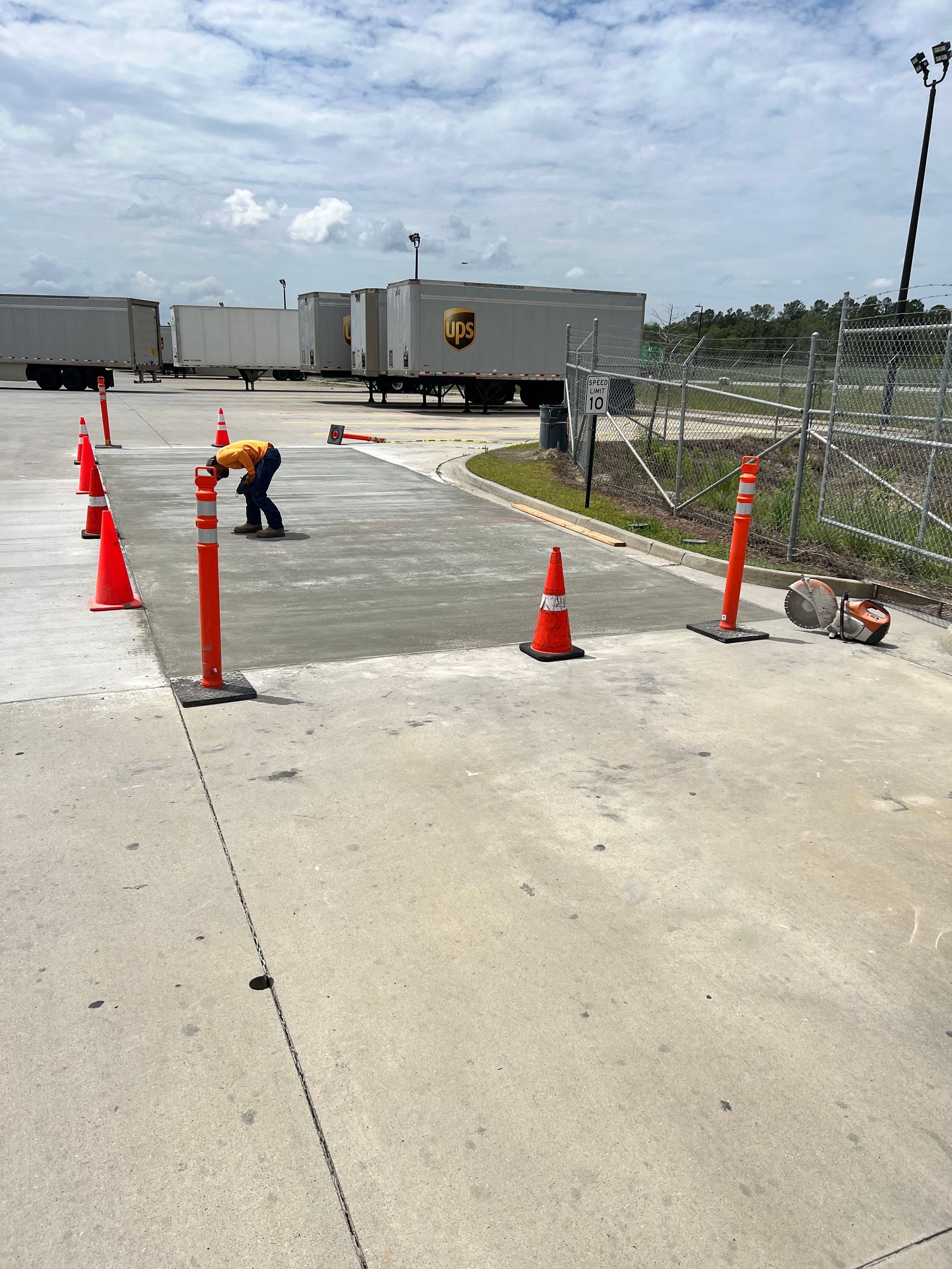 A man is working on a concrete road in front of a ups truck