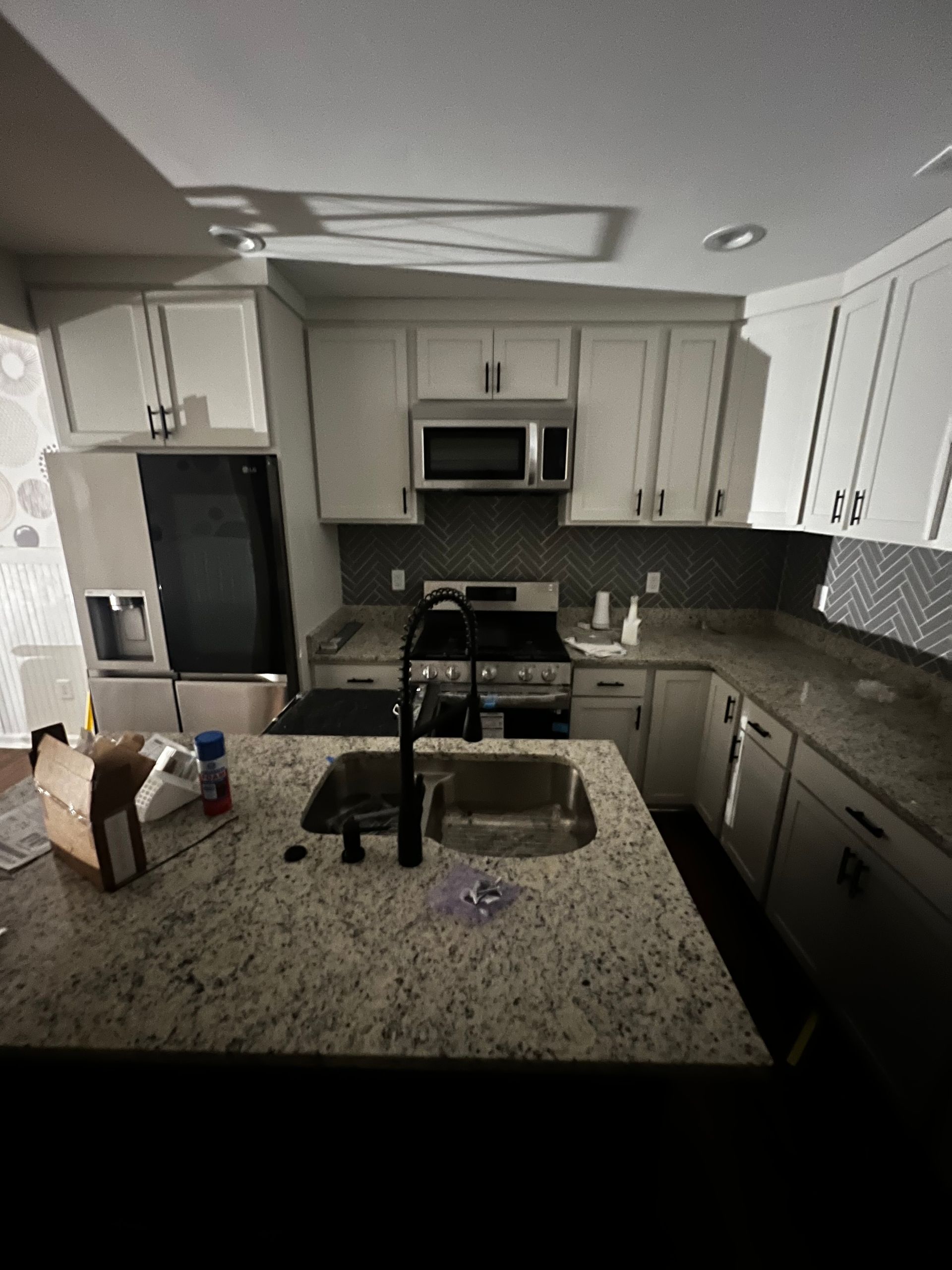 A kitchen with white cabinets and granite counter tops