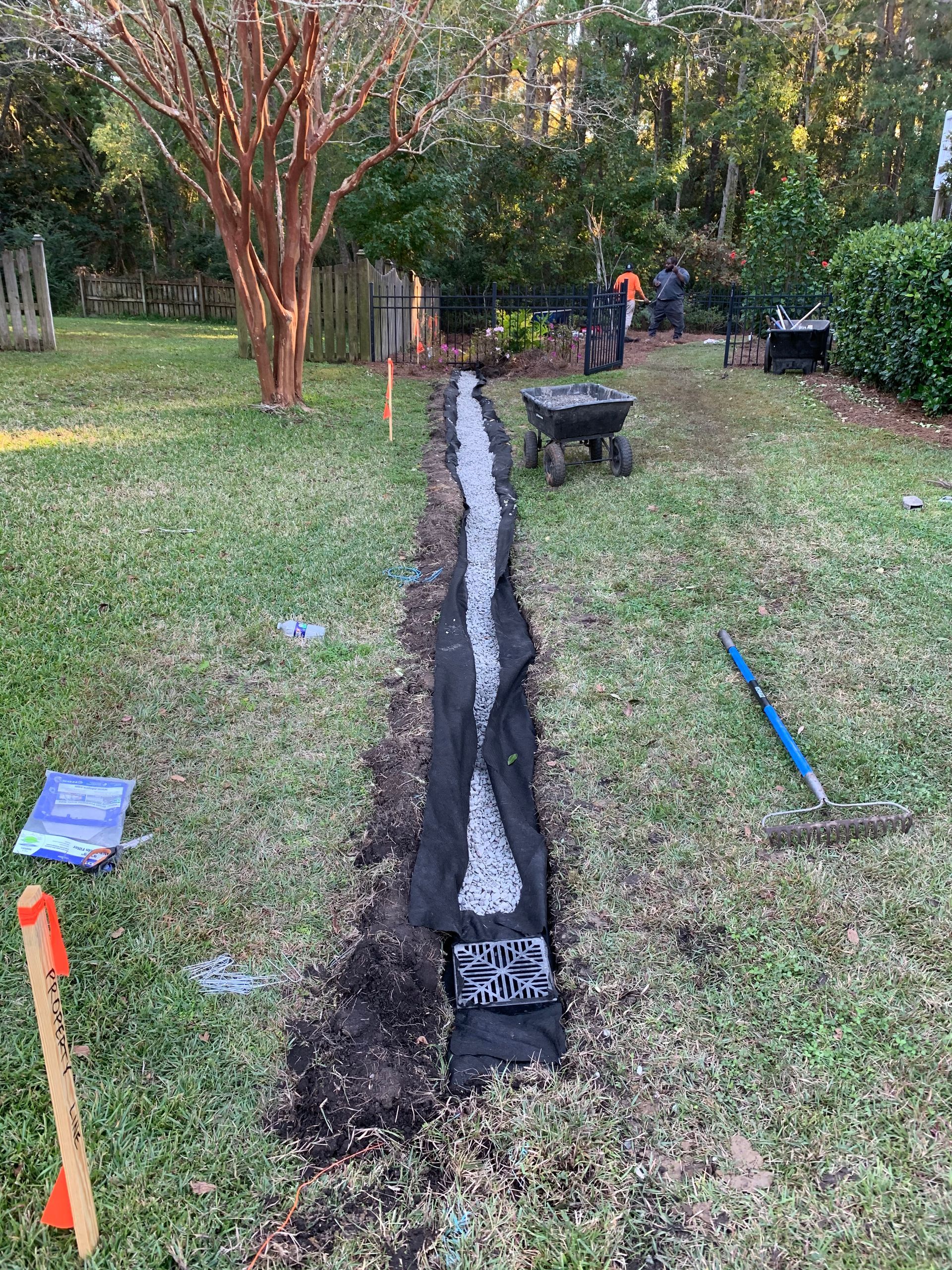 A drainage system is being installed in a backyard.