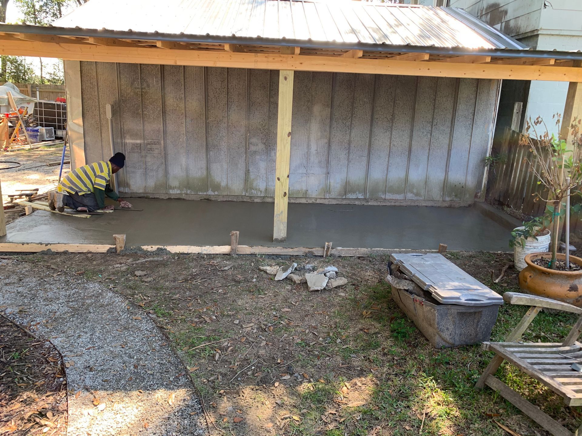 A man is kneeling on a concrete surface in front of a building.