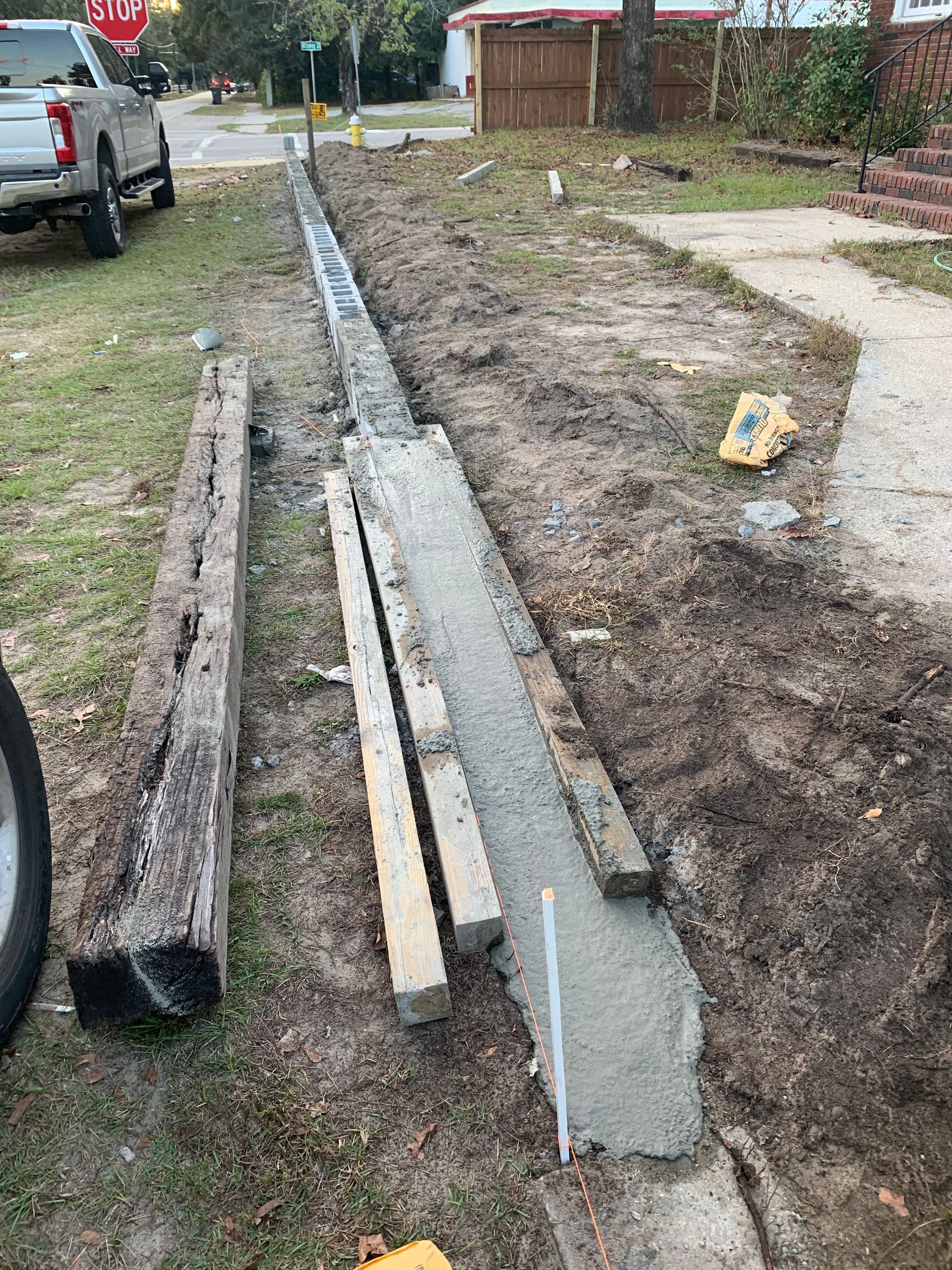 A truck is parked on the side of the road next to a concrete curb.