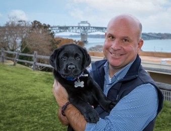 Matt, owner of the Yorktown Beach Hotel, holding a puppy