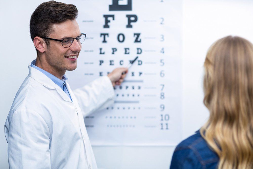 Optometrist taking eye test of female patient — Optometrist in Banora Point, NSW