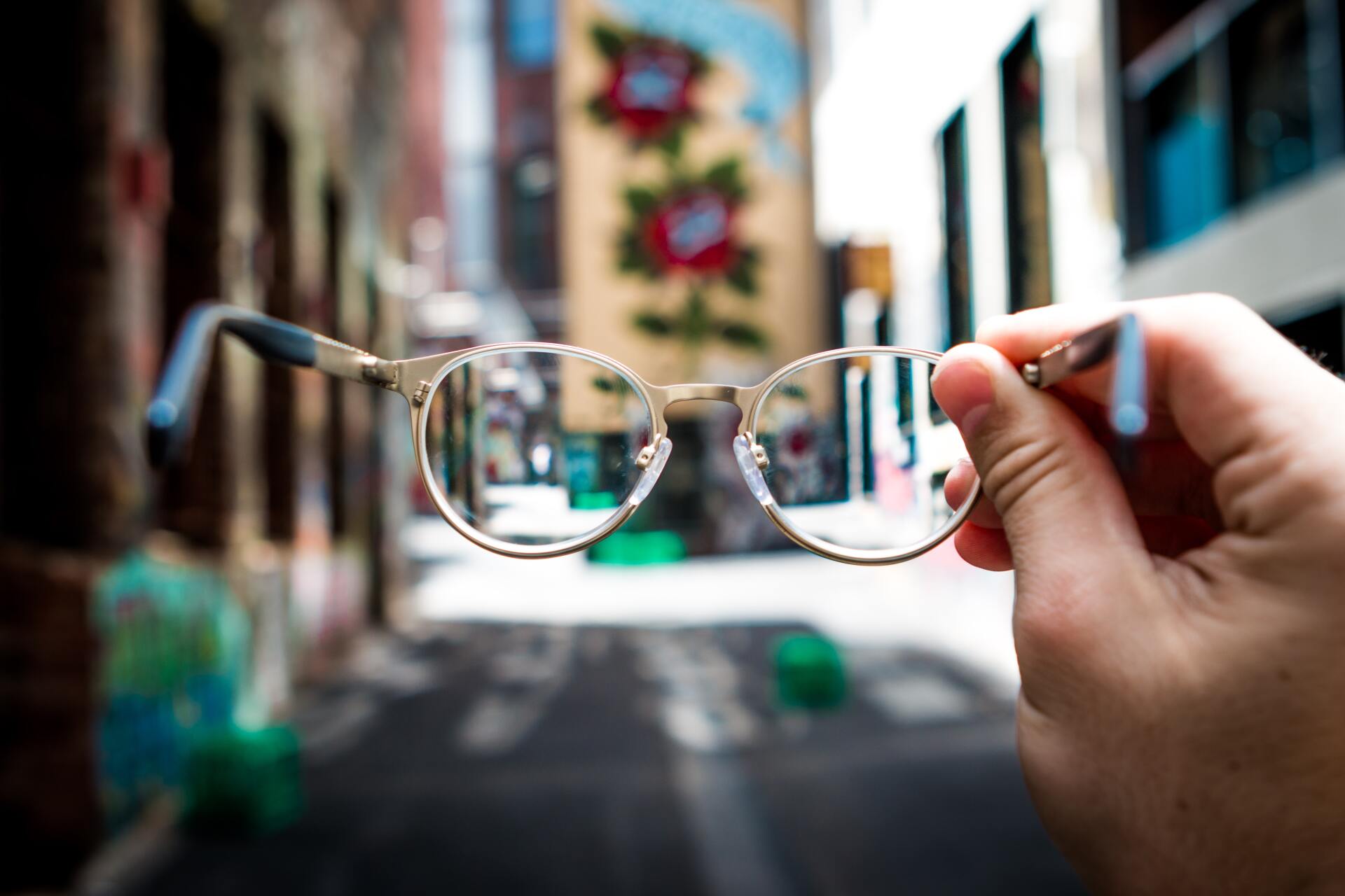 Hands holding Glasses — Optometrist in Banora Point, NSW