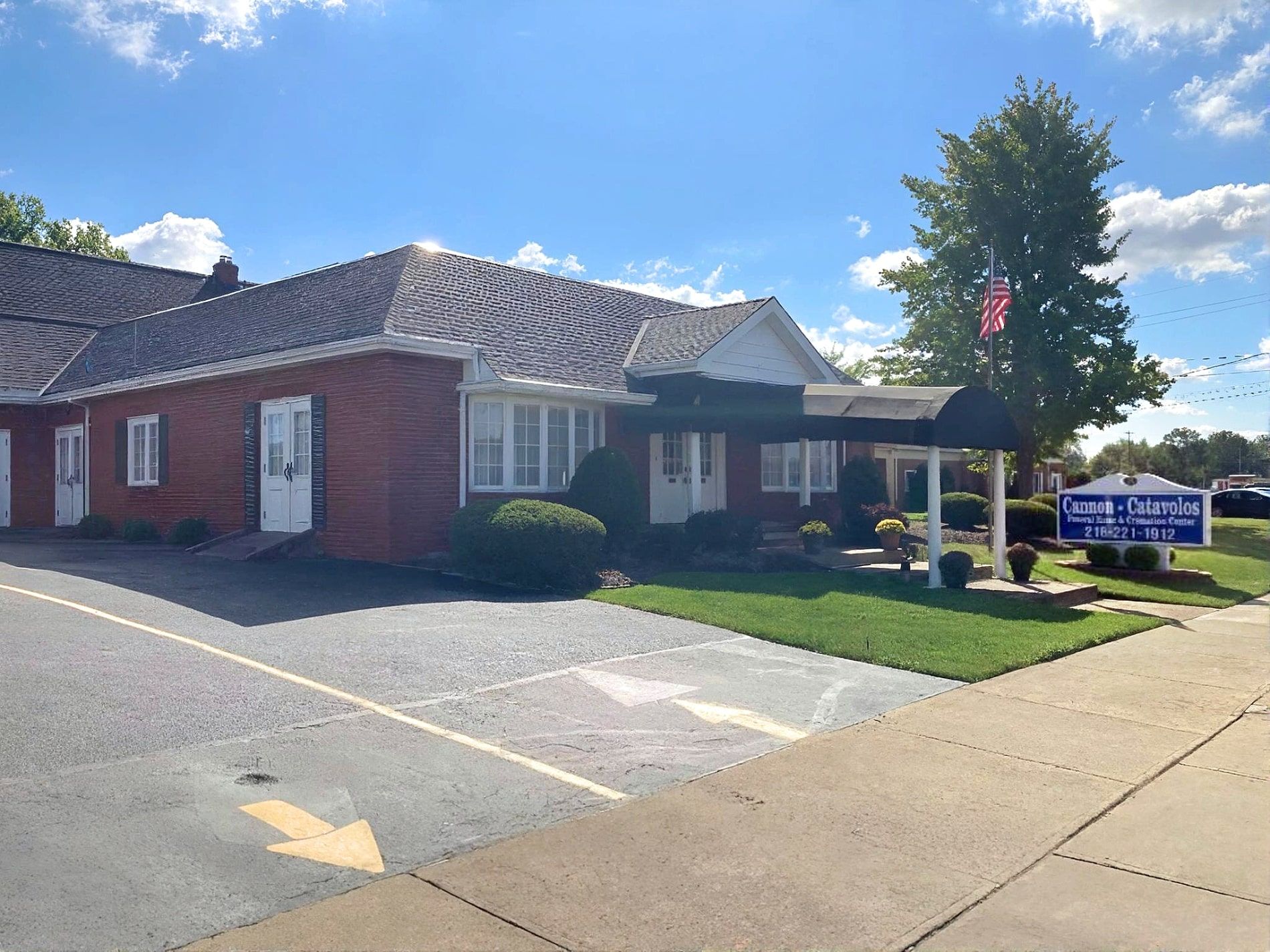 Brick building with awning over entrance, a sign for 
