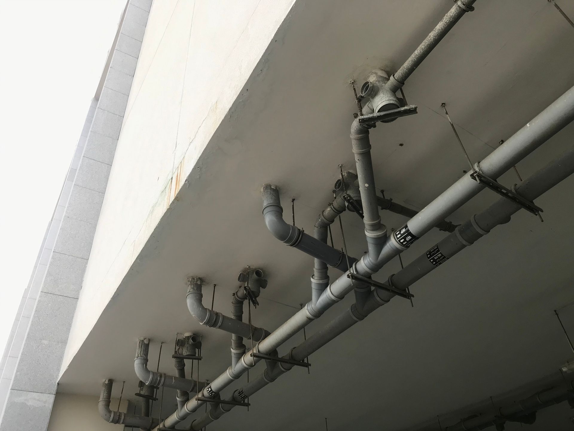 A photo of PVC plumbing works for a toilet constructed beneath a concrete slab.