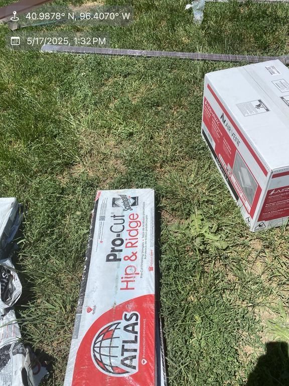 A box of atlas hip and ridge is sitting on the grass.