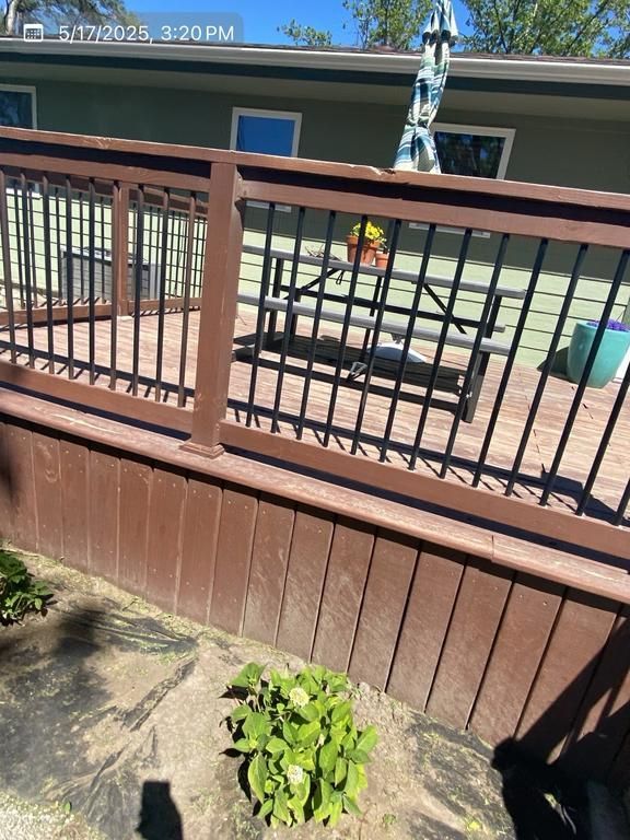 A deck with a metal railing and a bench on it