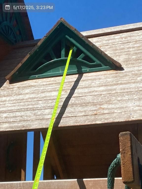 A yellow tape measure is being used to measure a wooden structure