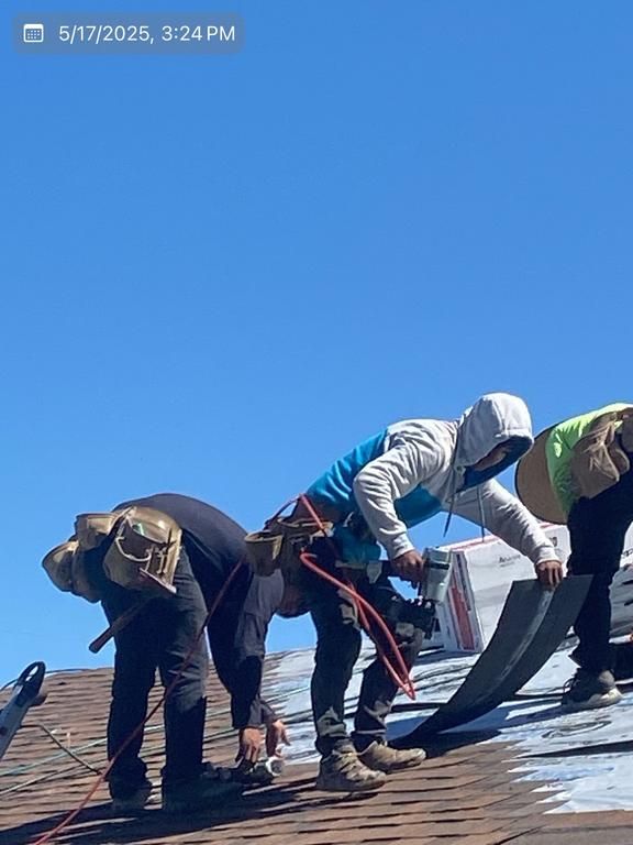 A group of men are working on a roof.