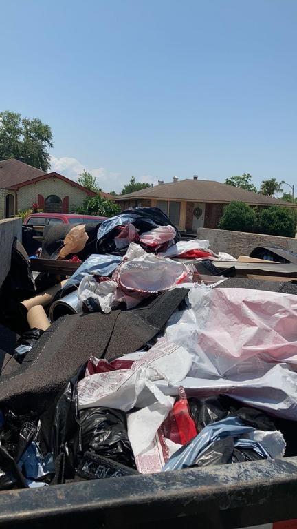 There is a lot of trash in the back of a truck.