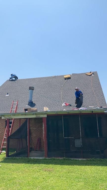 A man is working on the roof of a house.
