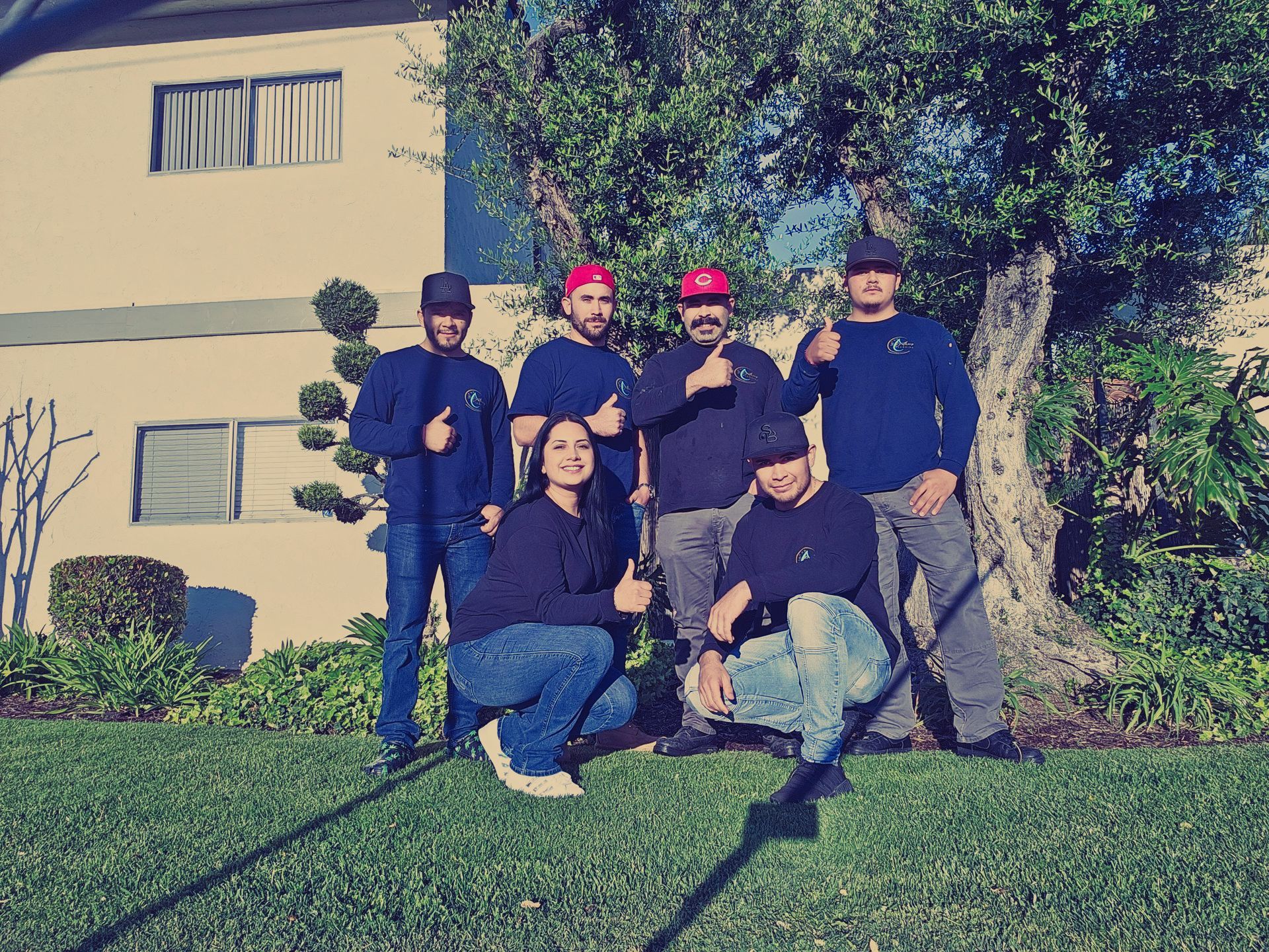 A group of people are posing for a picture in front of a building.