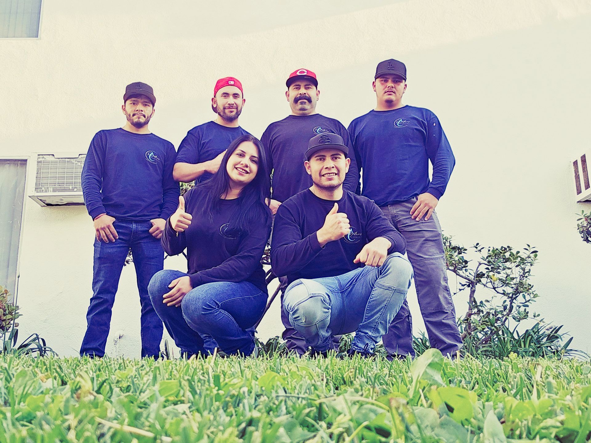 A group of people posing for a picture on the grass