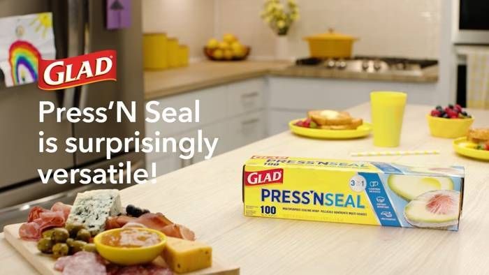 Glad trash bags displayed on a kitchen counter with the Glad logo visible, promoting a "Save $10" offer.